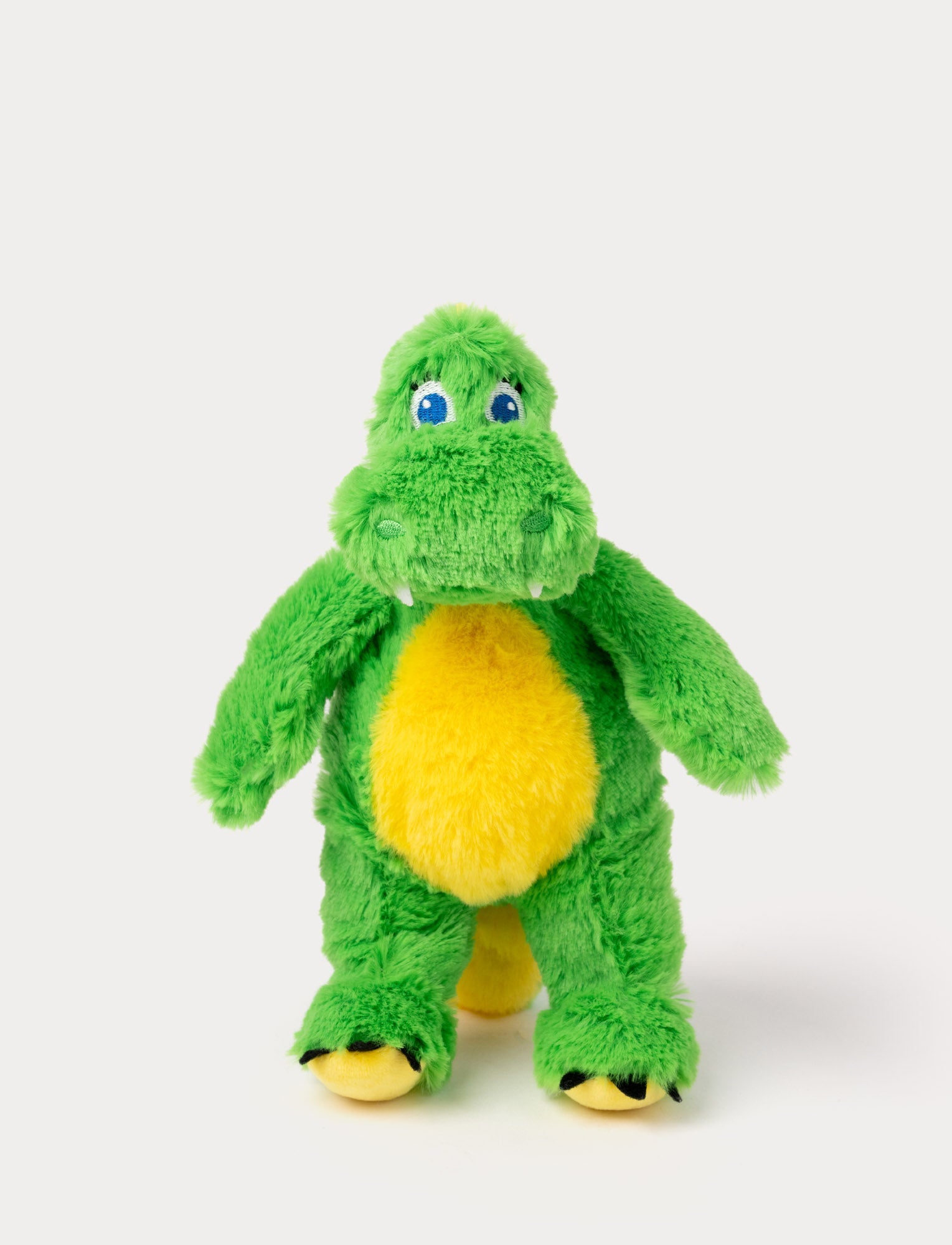 Image of A plush green dinosaur with a round yellow belly, blue embroidered eyes, and small white teeth. It has a soft, fuzzy texture and a friendly expression.