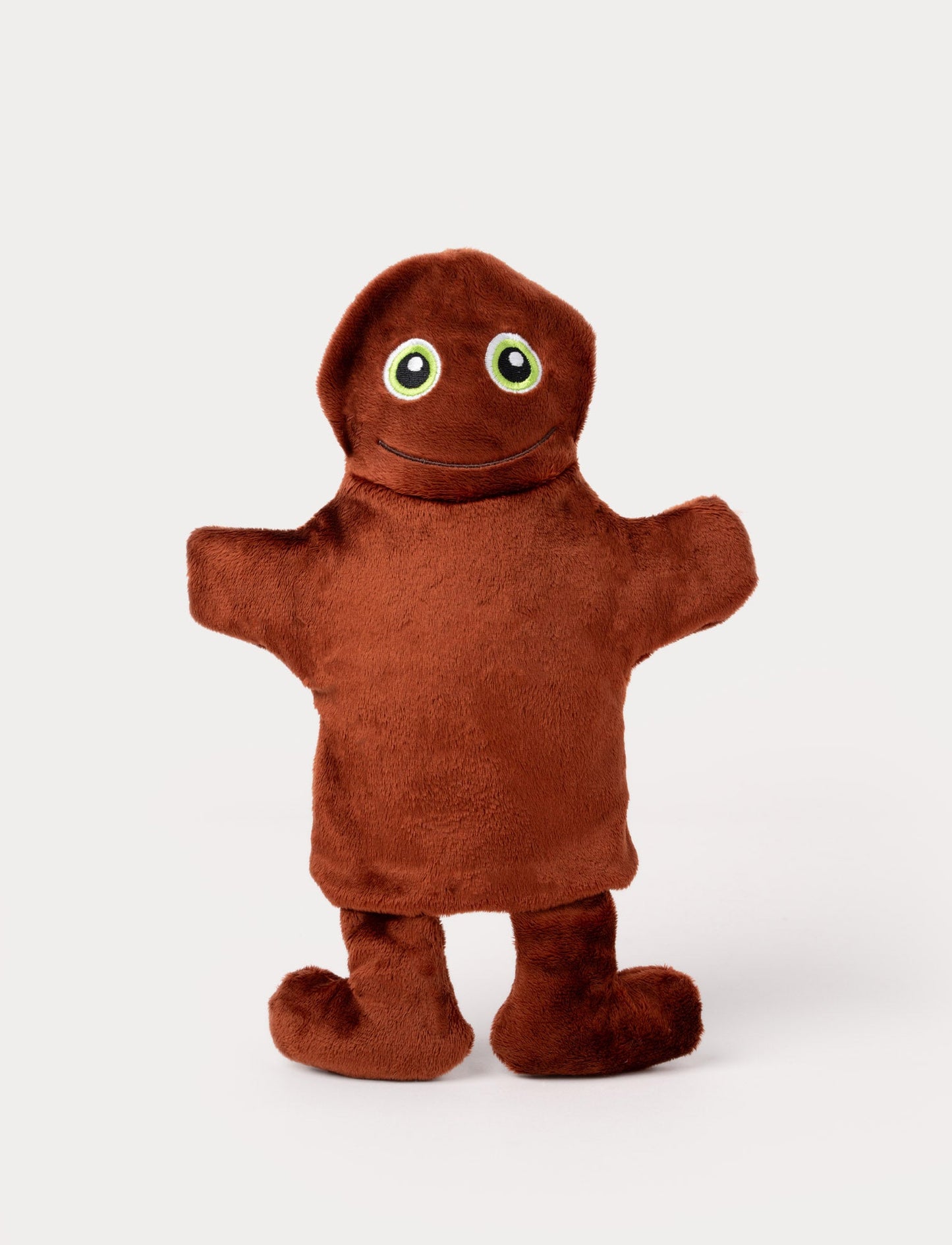 Brown hand puppet with a rounded head, big green eyes, outstretched arms, and a friendly embroidered smile.