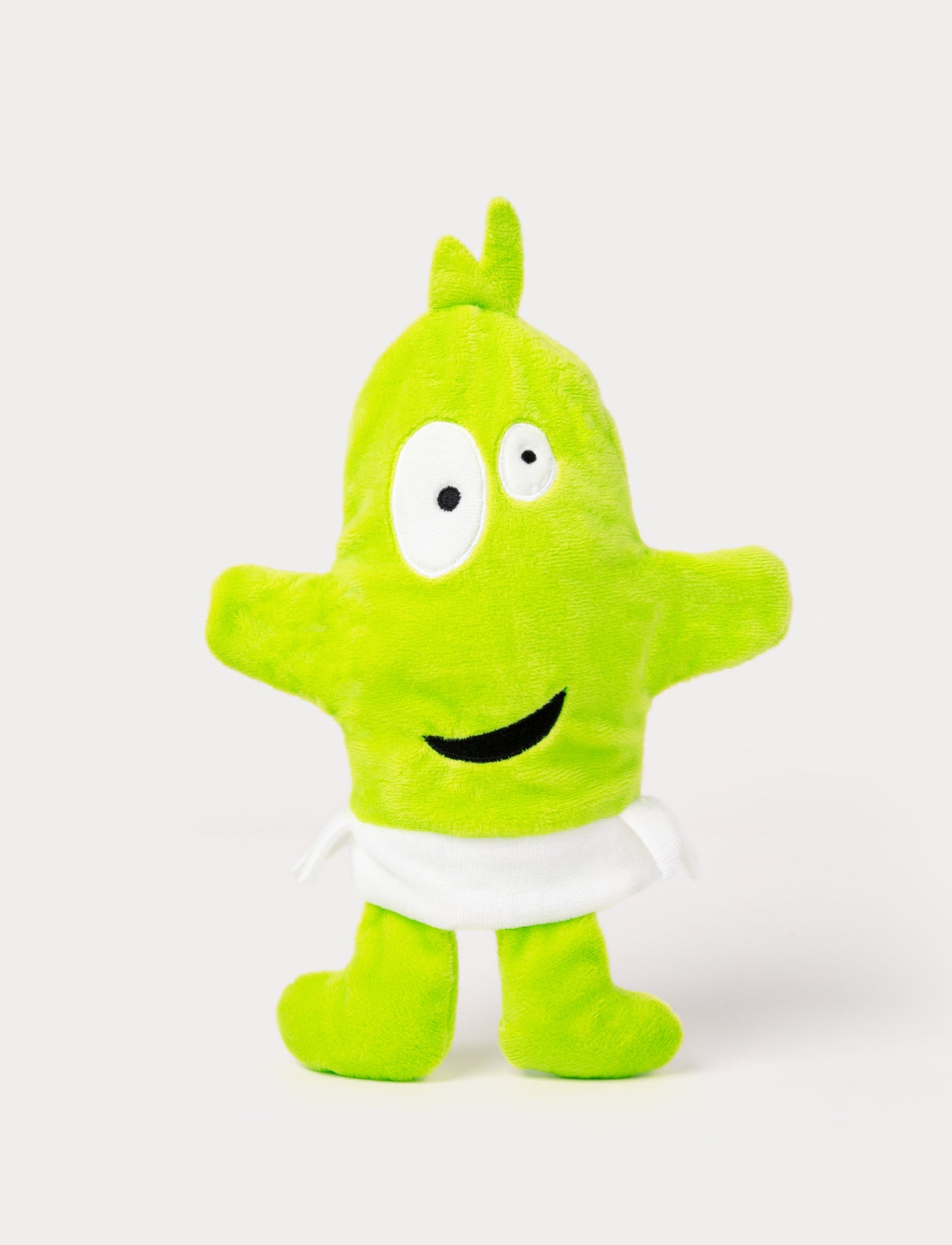 Green hand puppet with a tuft on top, large uneven eyes, a playful smile, and a white waistband.