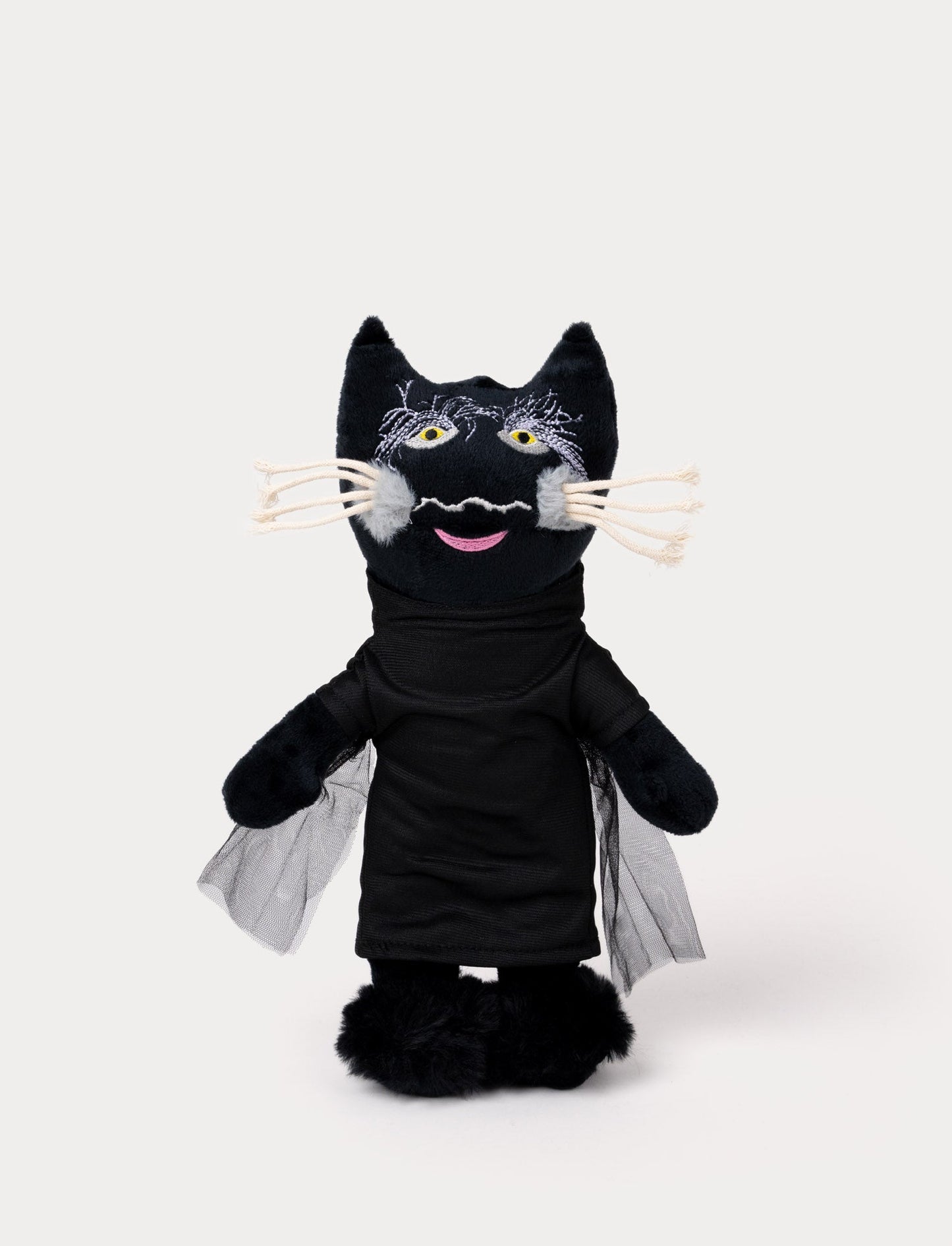 A plush toy of a black cat wearing a dark outfit with mesh cape detail.