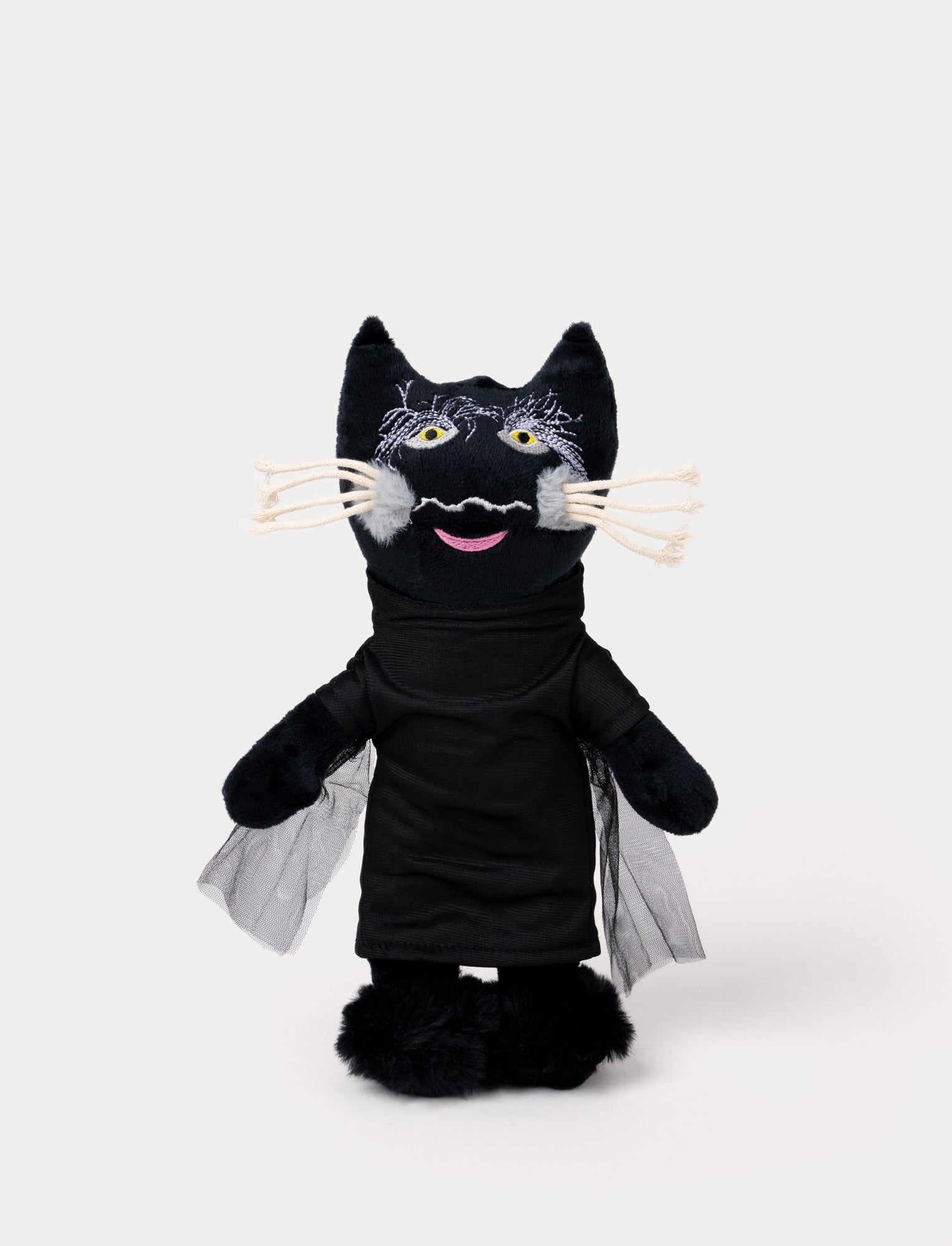 Image of A plush toy of a black cat wearing a dark outfit with mesh cape detail.