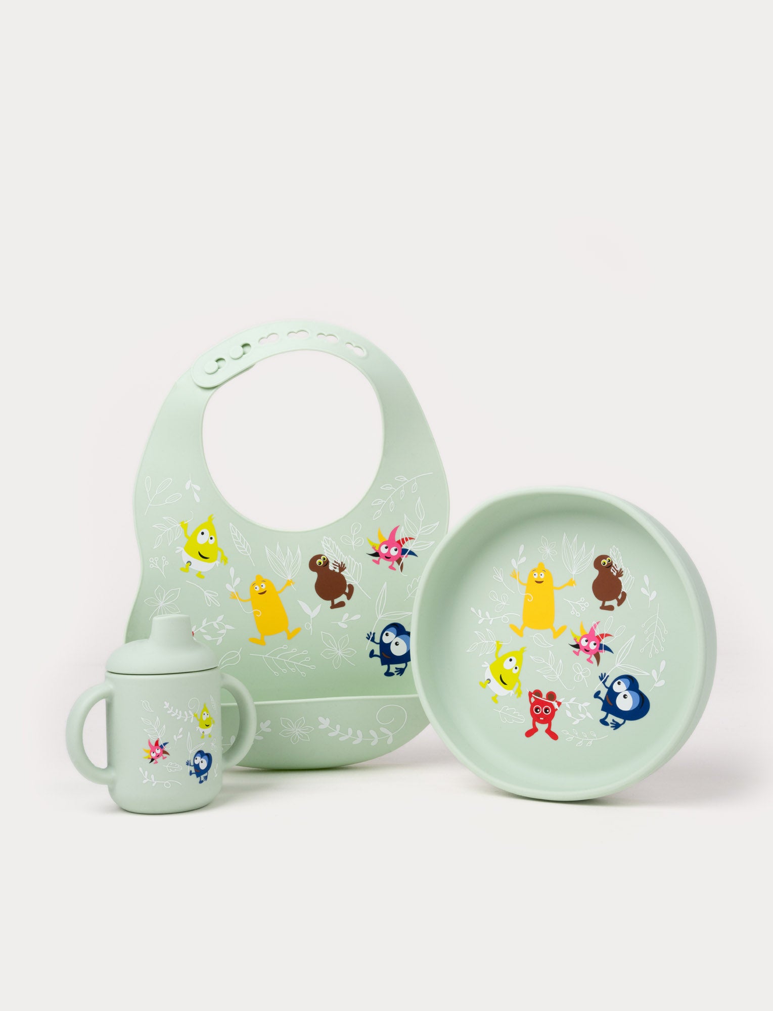 Image of Green silicone baby feeding set with a bib, sippy cup, and plate, decorated with Babblarna characters.