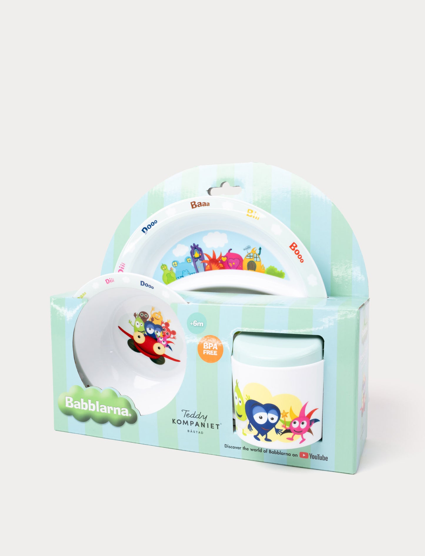 A children's dining set featuring Babblarna characters, including a plate, bowl, and cup in green packaging.