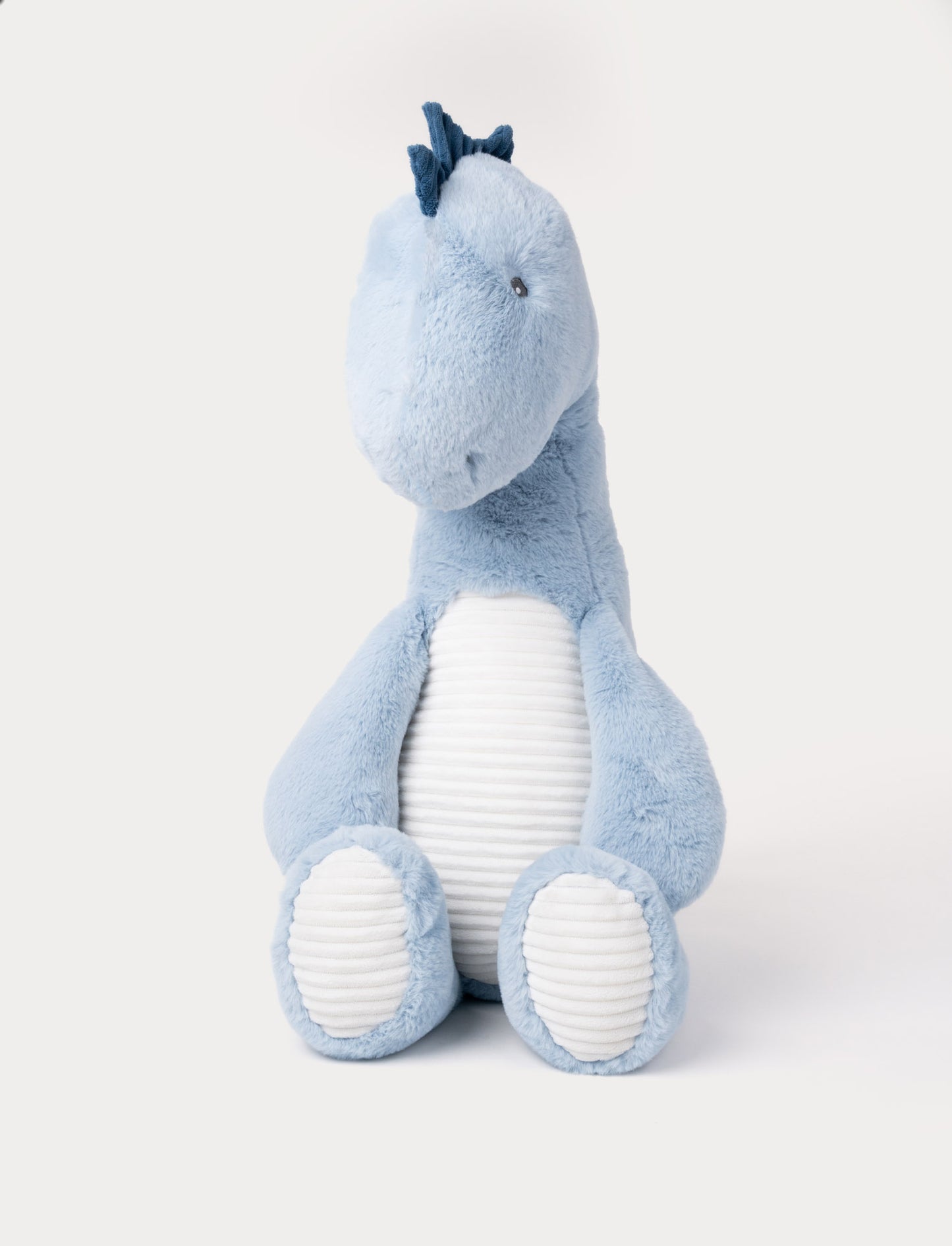 Soft blue plush dinosaur with a white ribbed belly, dark blue spikes, and a friendly expression.