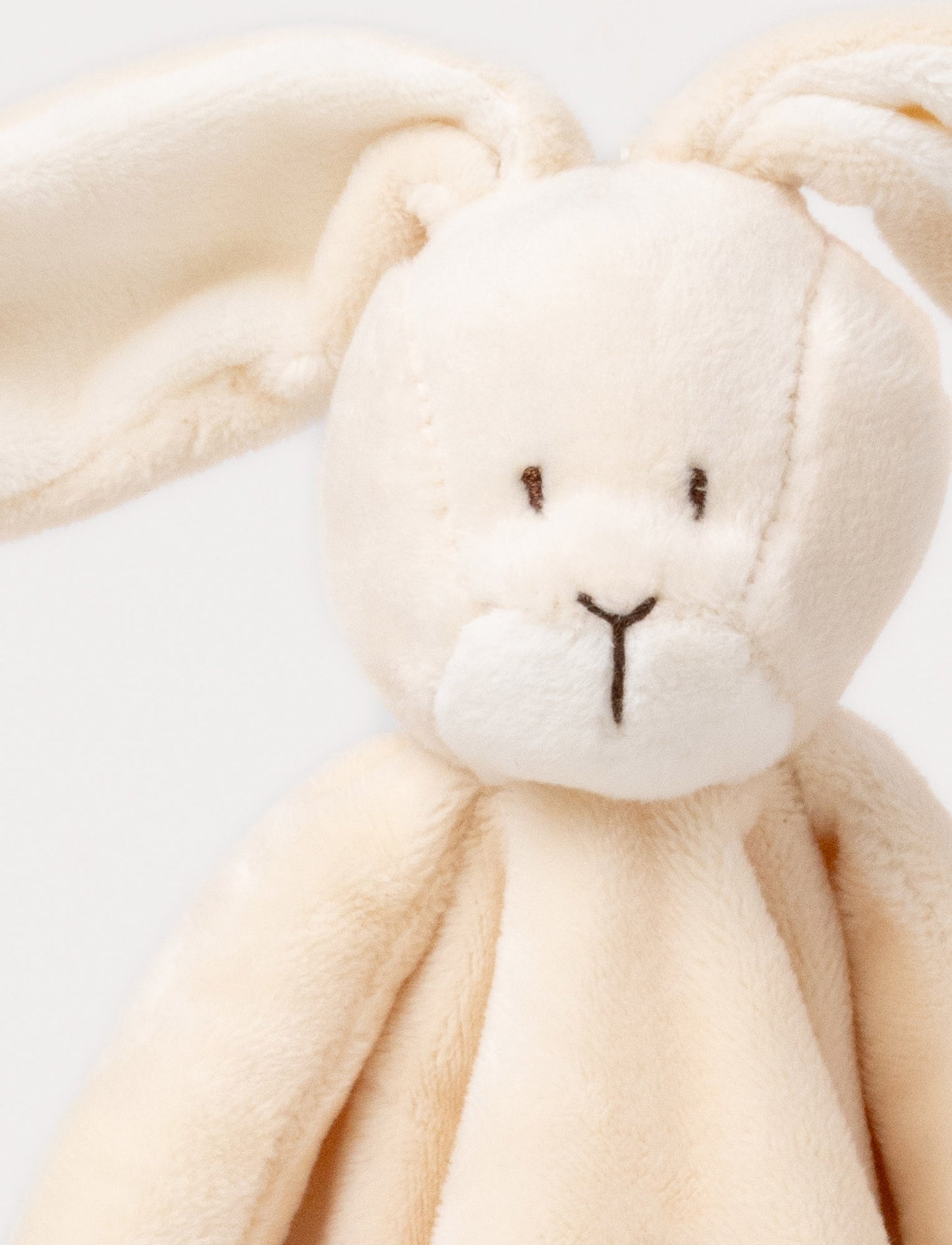 A beige-brown baby blanket with a soft plush bunny, white contrast details