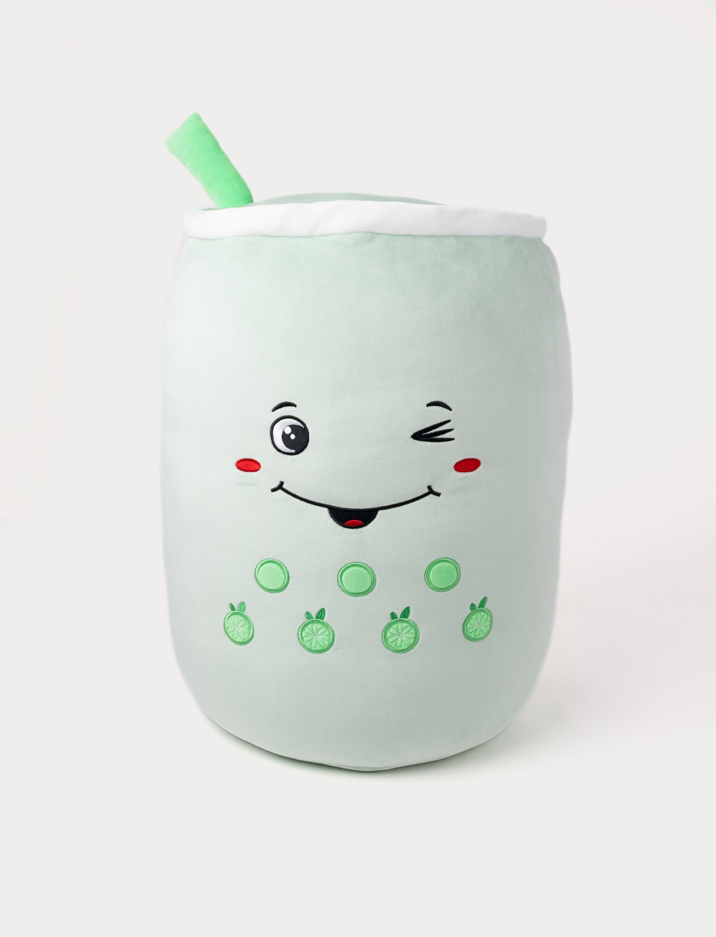 Soft plush bubble tea pillow in light green with a winking face, embroidered toppings, and a plush straw.