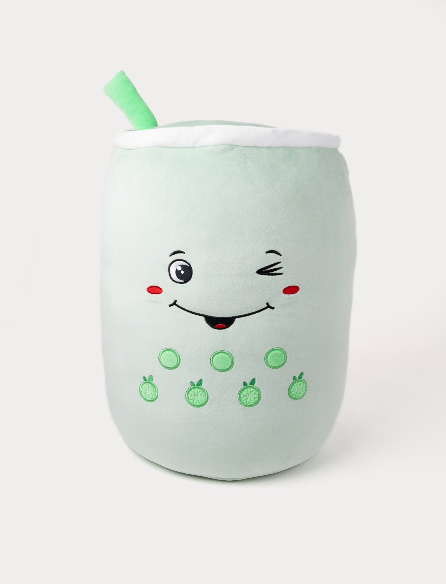 Image of Soft plush bubble tea pillow in light green with a winking face, embroidered toppings, and a plush straw.