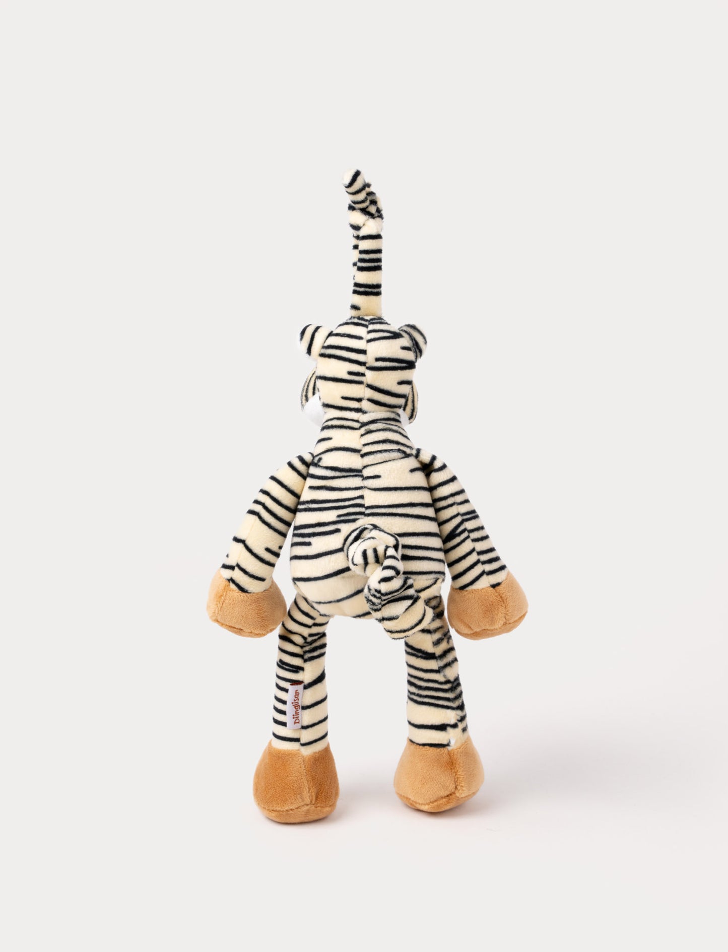 A plush tiger music box with black stripes, a white belly, beige paws, and a fabric loop for hanging