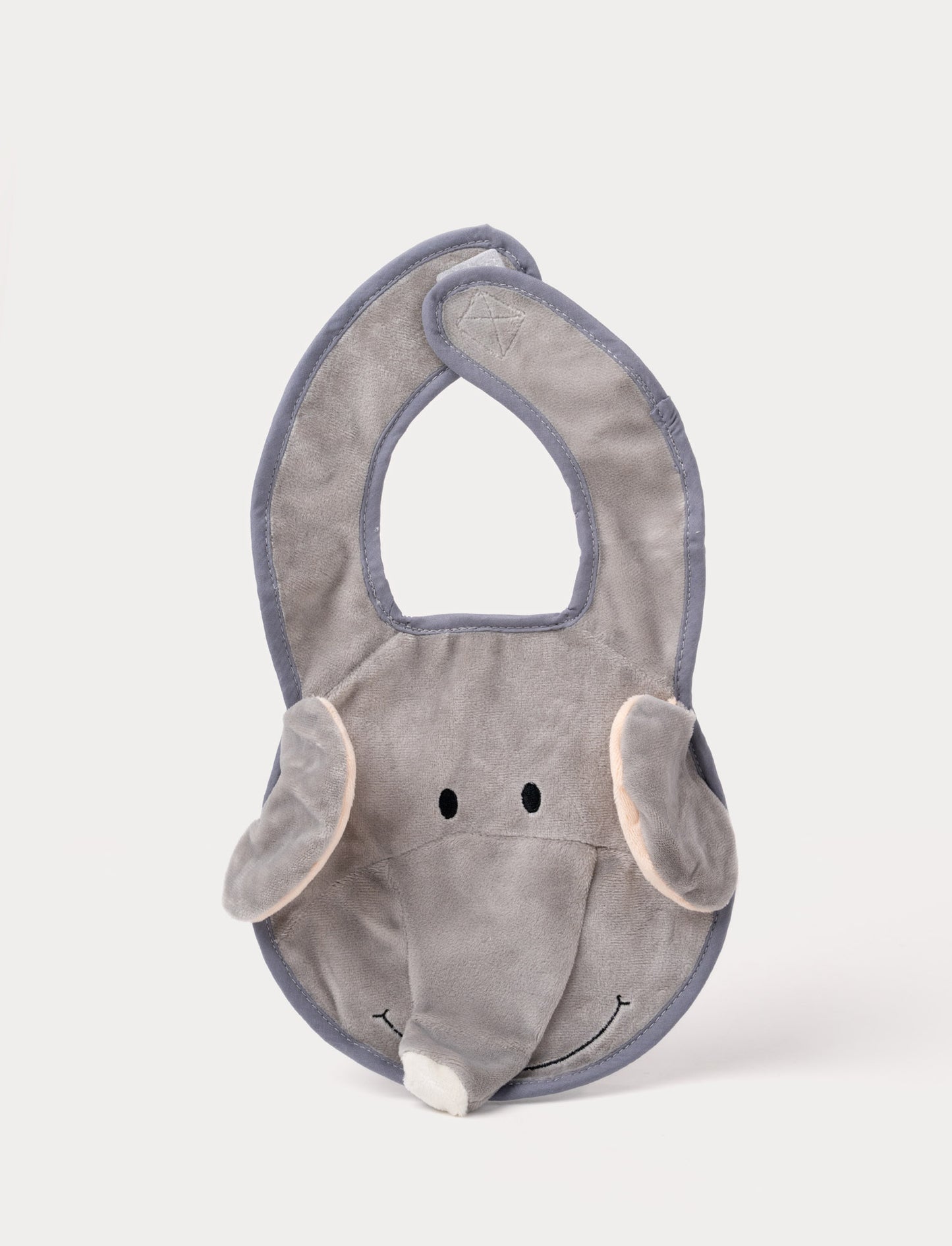 A grey elephant-shaped baby bib with floppy ears, a soft trunk, and a stitched smiling face.