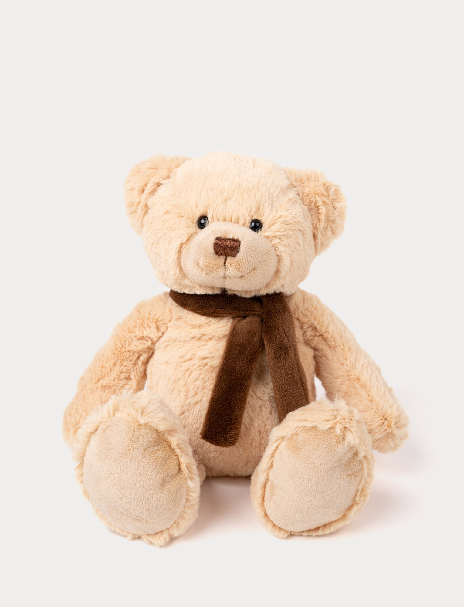 Image of Classic beige teddy bear with black eyes, a stitched brown nose, and a soft brown scarf around its neck.