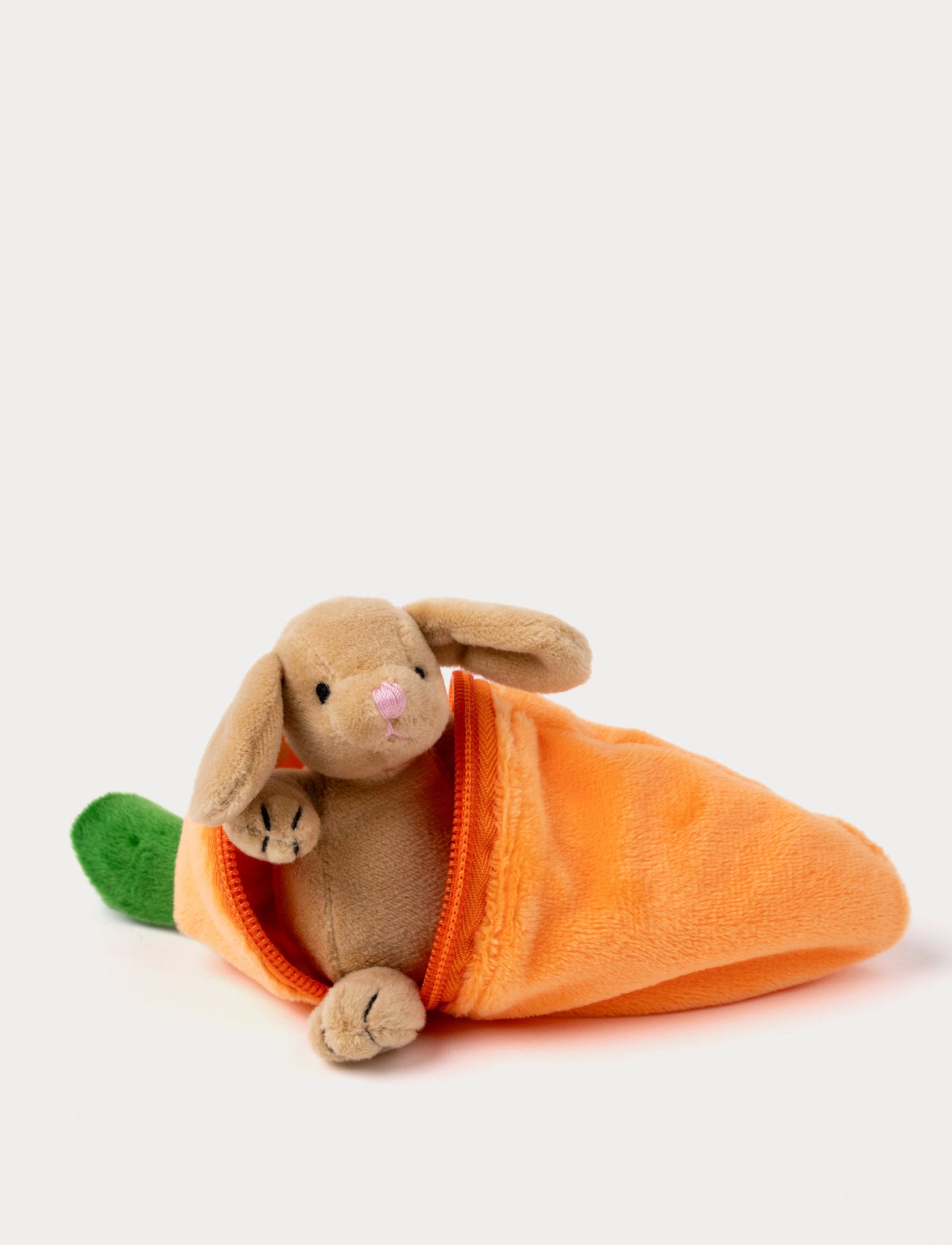 A small plush bunny peeks out from a soft, zippered carrot-shaped pouch.