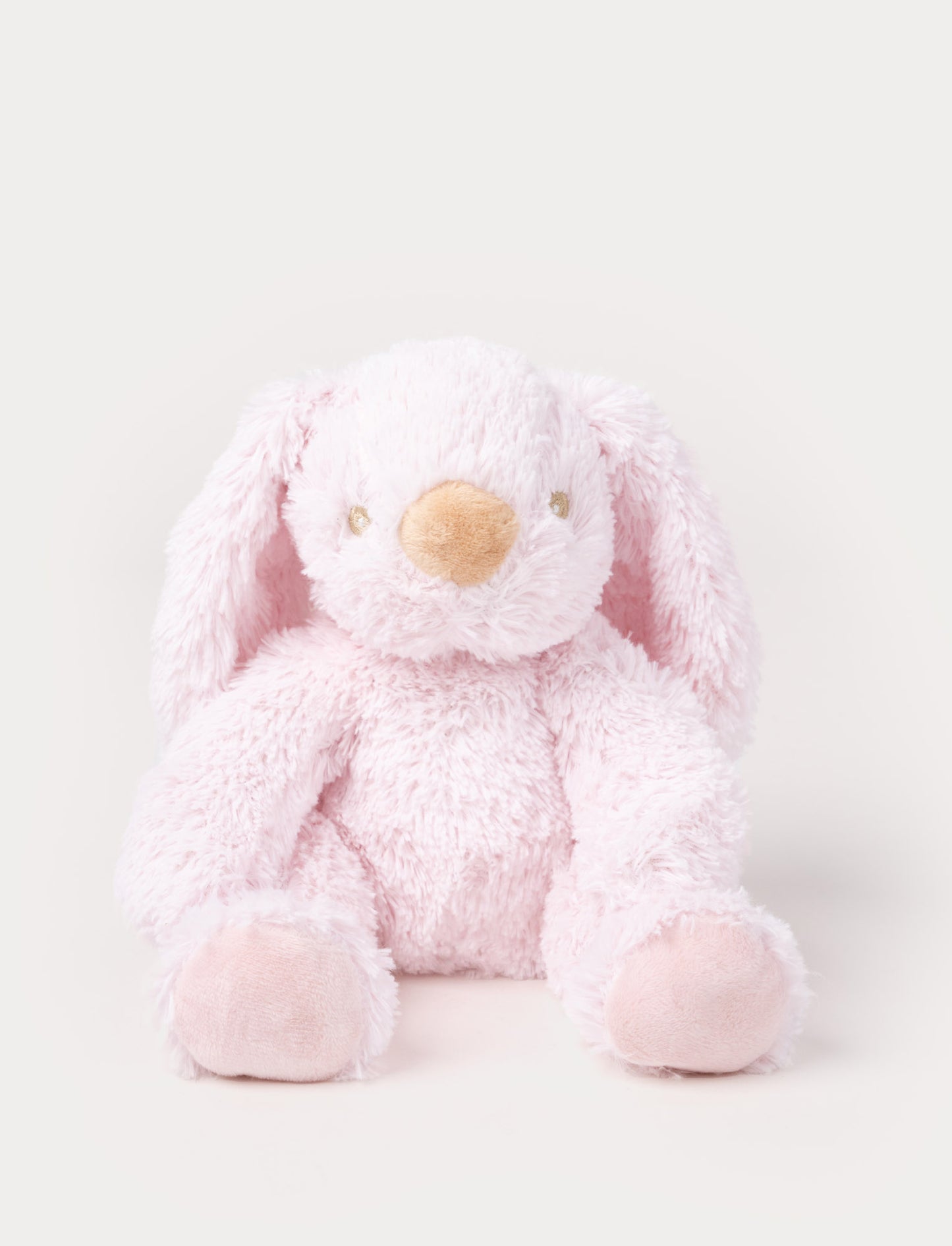 A soft pink plush bunny with floppy ears, a beige nose, and golden-stitched eyes.