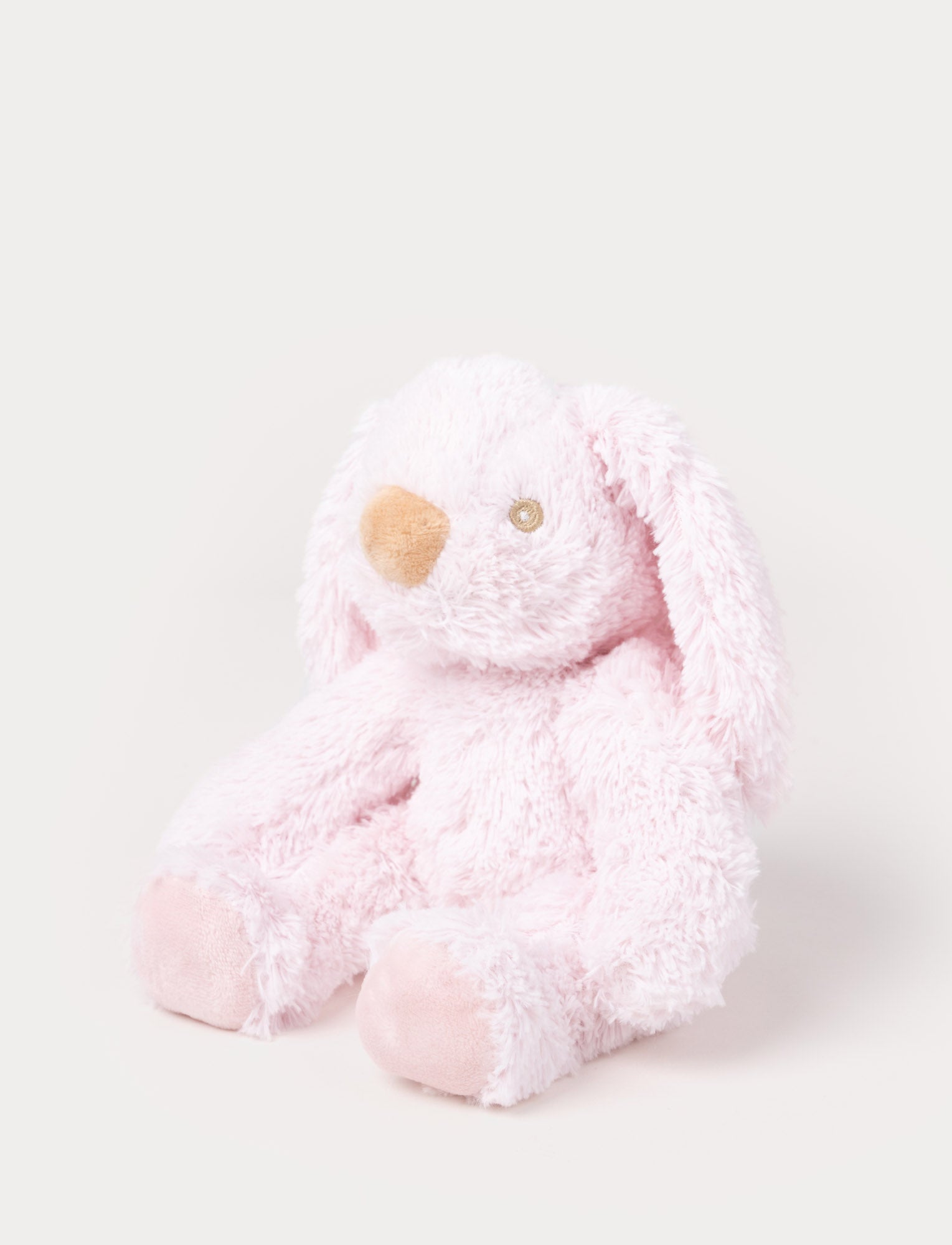 Image of A soft pink plush bunny with floppy ears, a beige nose, and golden-stitched eyes