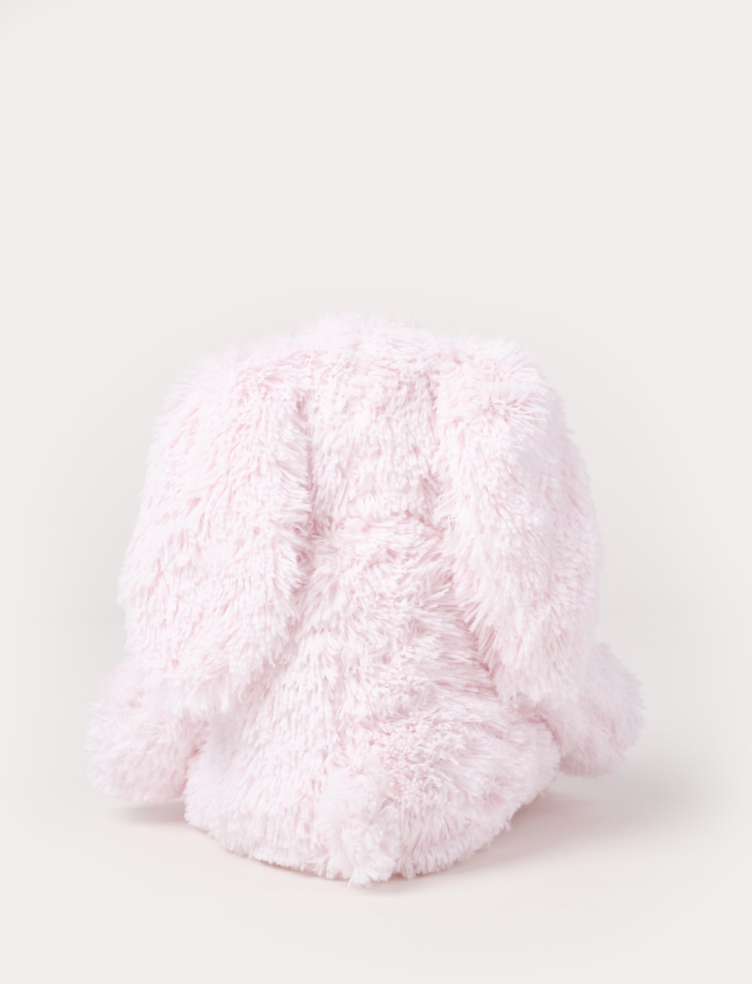 Image of A soft pink plush bunny with floppy ears, a beige nose, and golden-stitched eyes