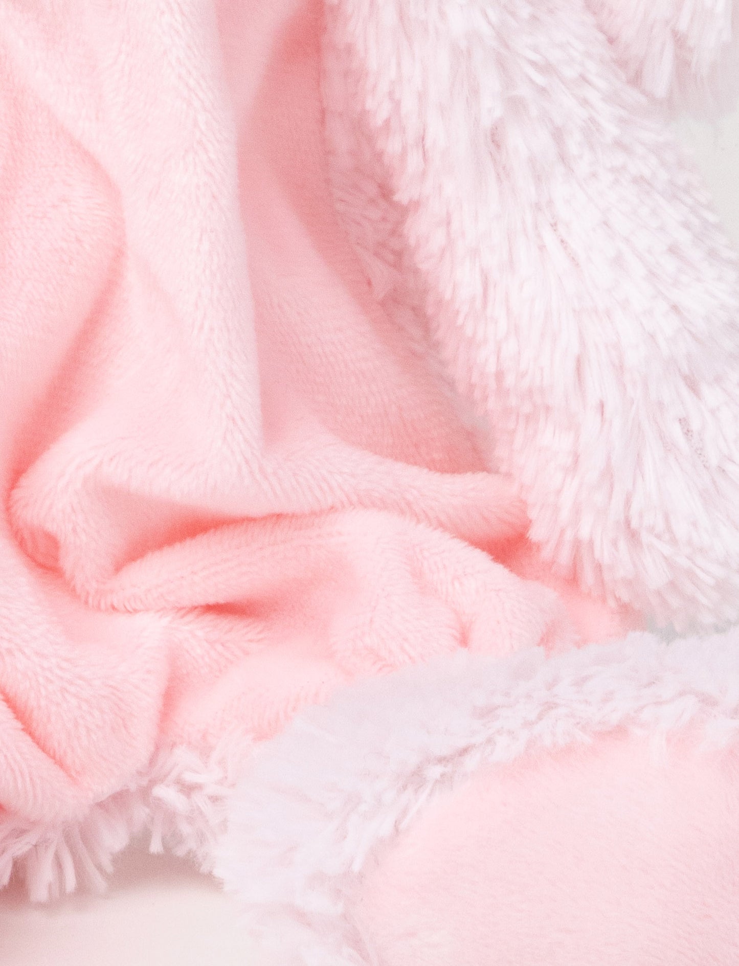 Soft plush bunny with a pink fabric body, floppy furry ears, and fluffy paws.