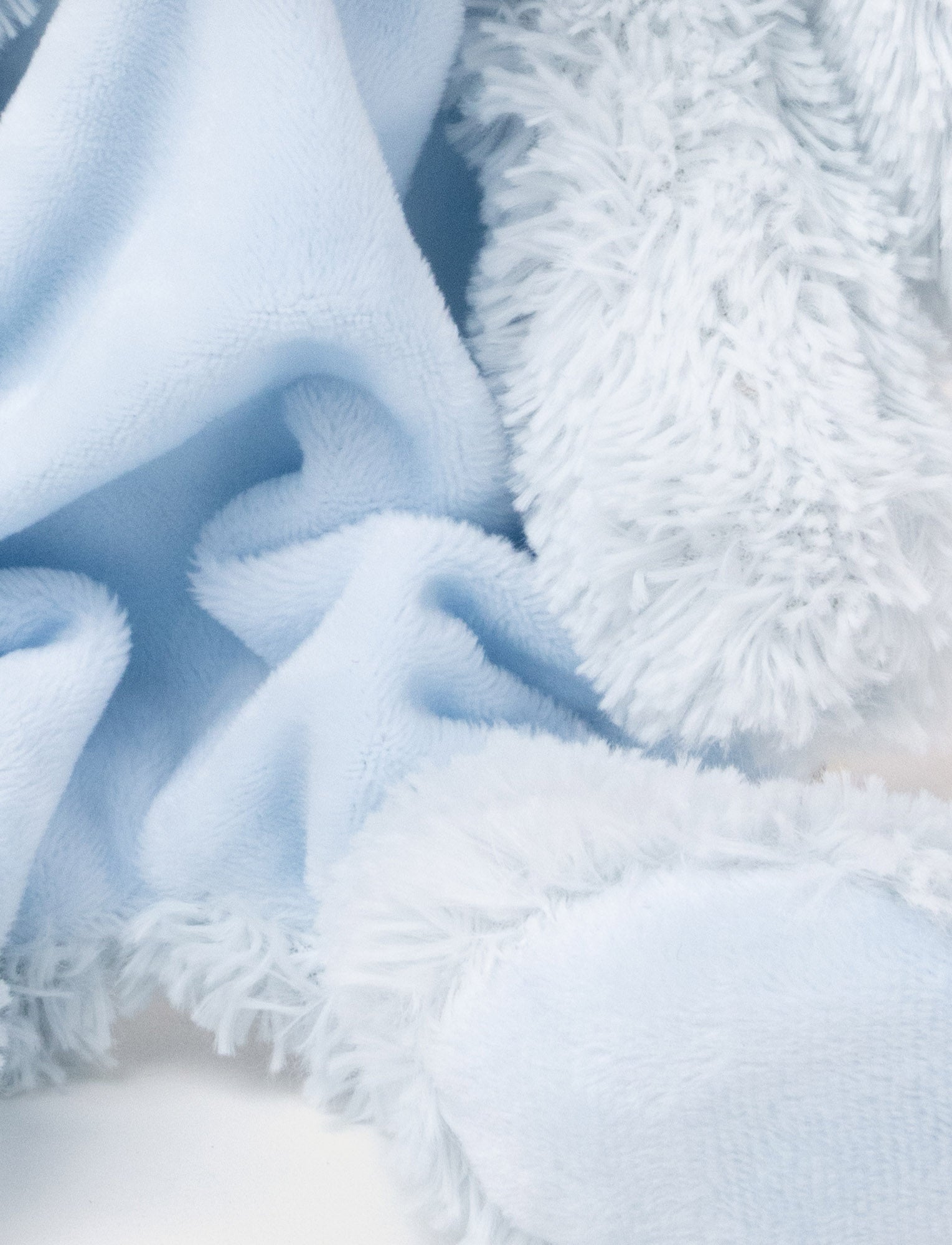 Image of Soft plush bunny blanket with a light blue fabric body, floppy furry ears, and fluffy paws.