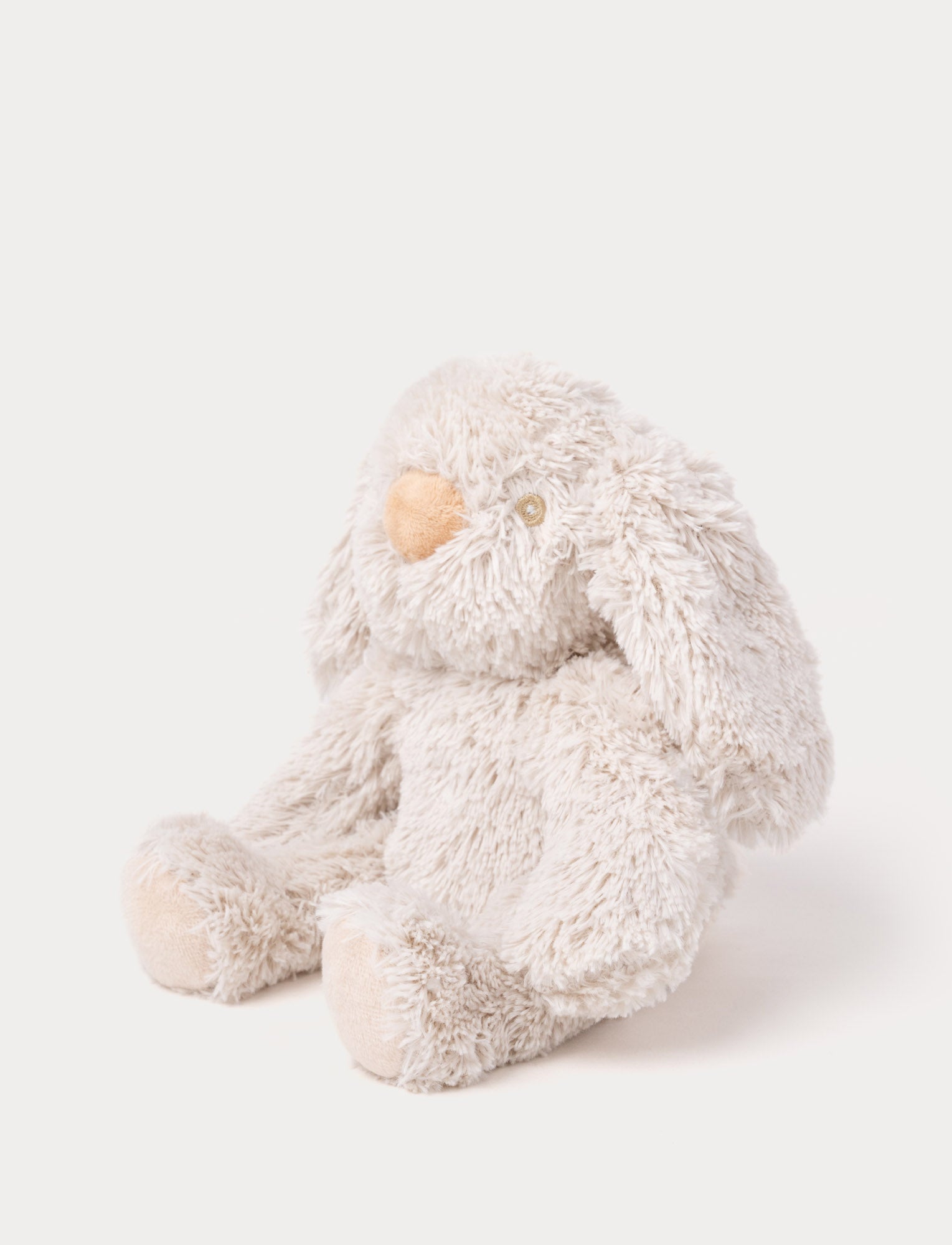 Image of A soft beige plush bunny with floppy ears, a brown nose, and golden-stitched eyes.
