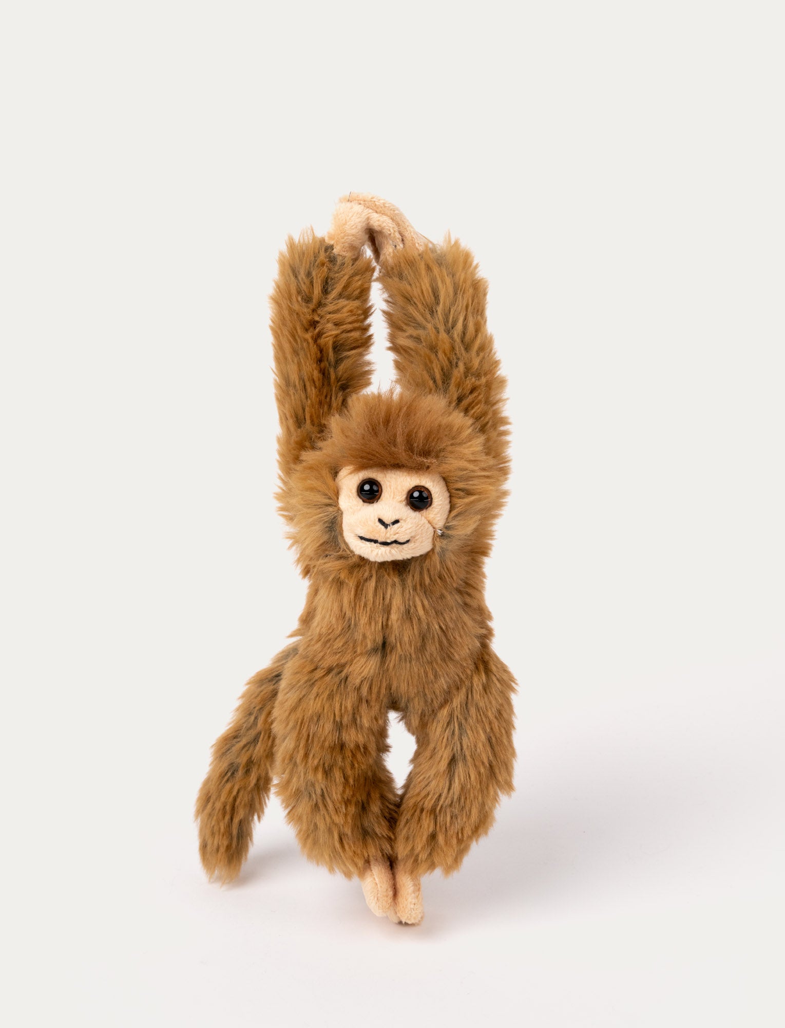 Image of A brown monkey with soft fur, a cheerful smile, and velcro fastenings on its hands and feet.