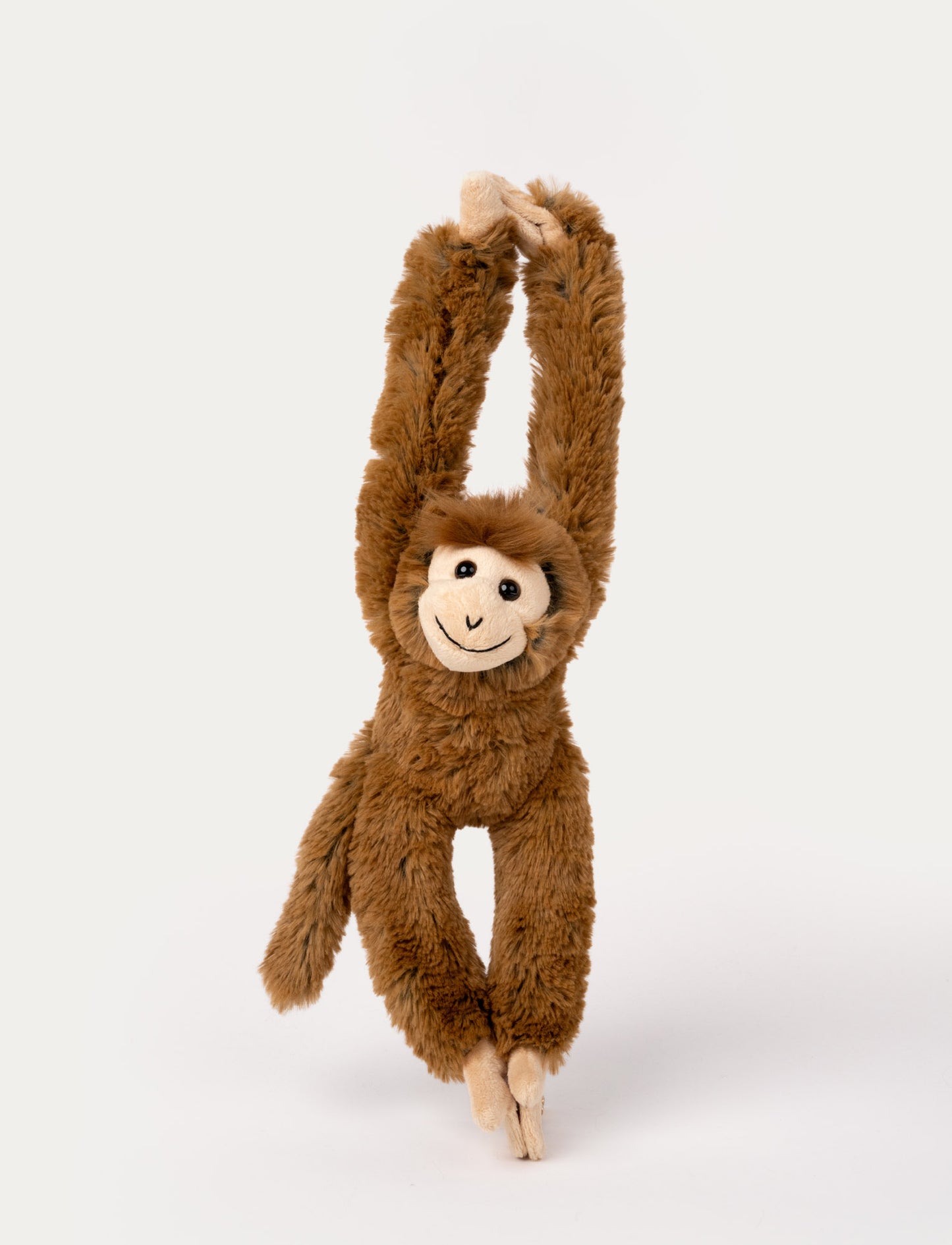 Brown plush monkey with long arms and a smiling face, designed to hang by its hands with Velcro.