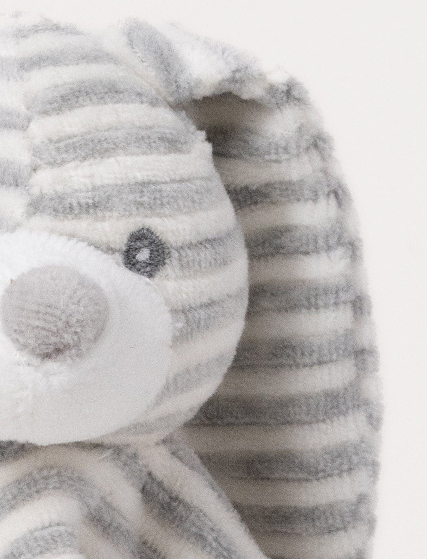 A grey and white striped plush bunny comforter with floppy ears and knotted fabric ends.