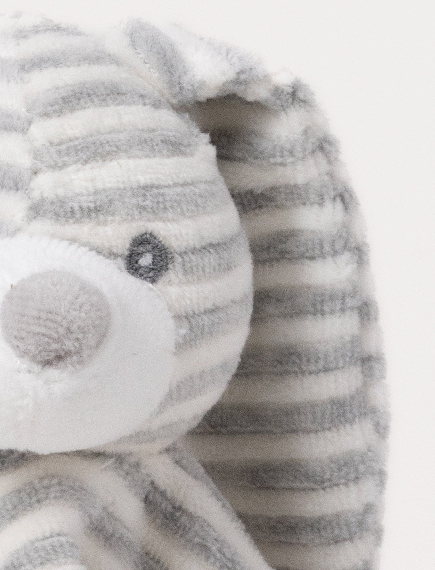 Image of A grey and white striped plush bunny comforter with floppy ears and knotted fabric ends.