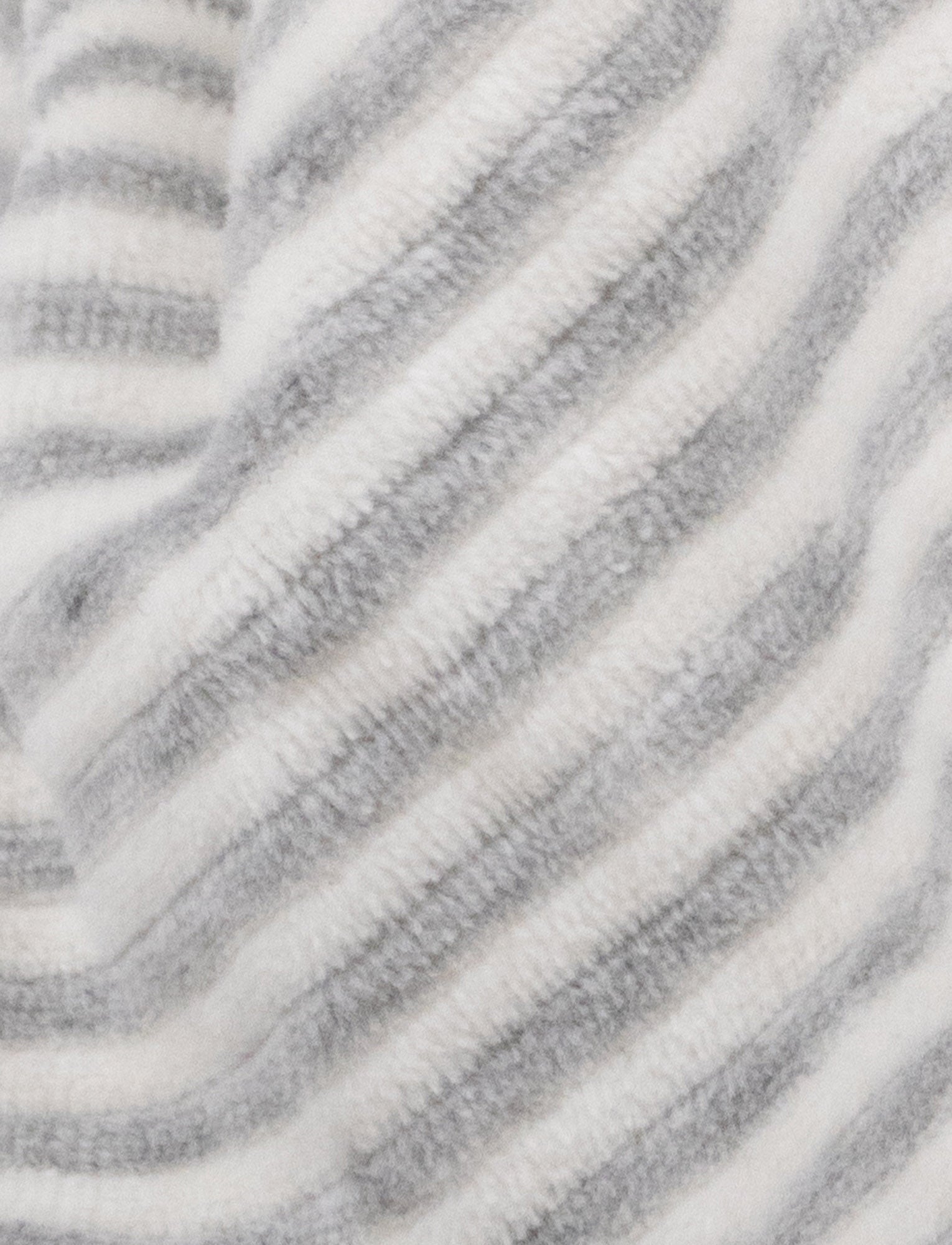 Image of A grey and white striped plush bunny comforter with floppy ears and knotted fabric ends.