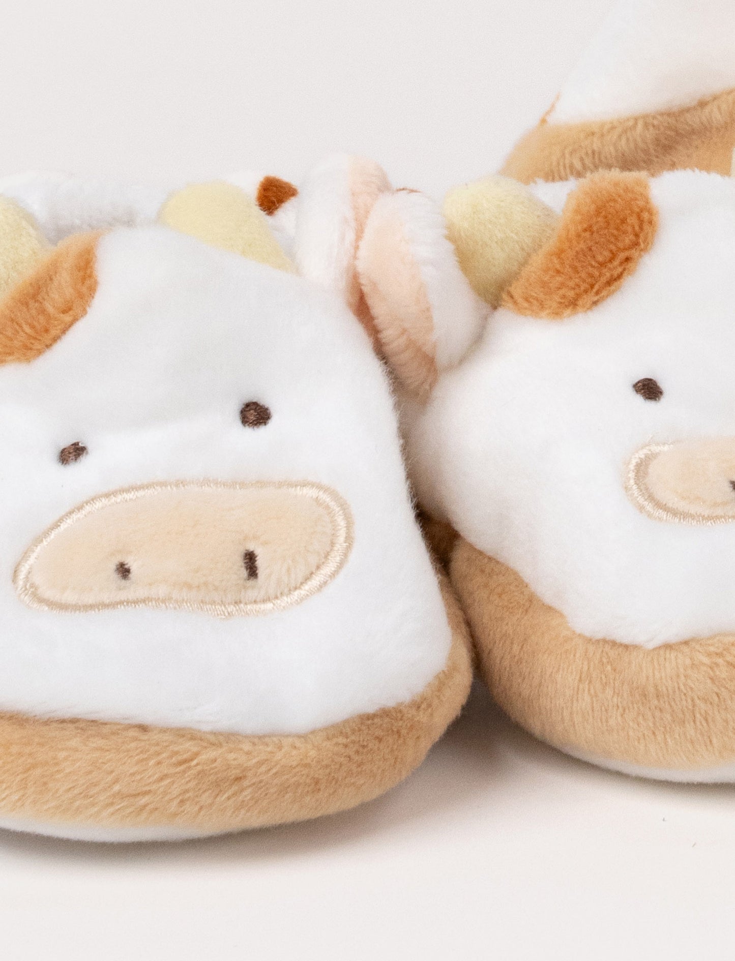 A Diinglisar gift box set featuring a plush cow comforter, matching slippers, and a soft toy ball.