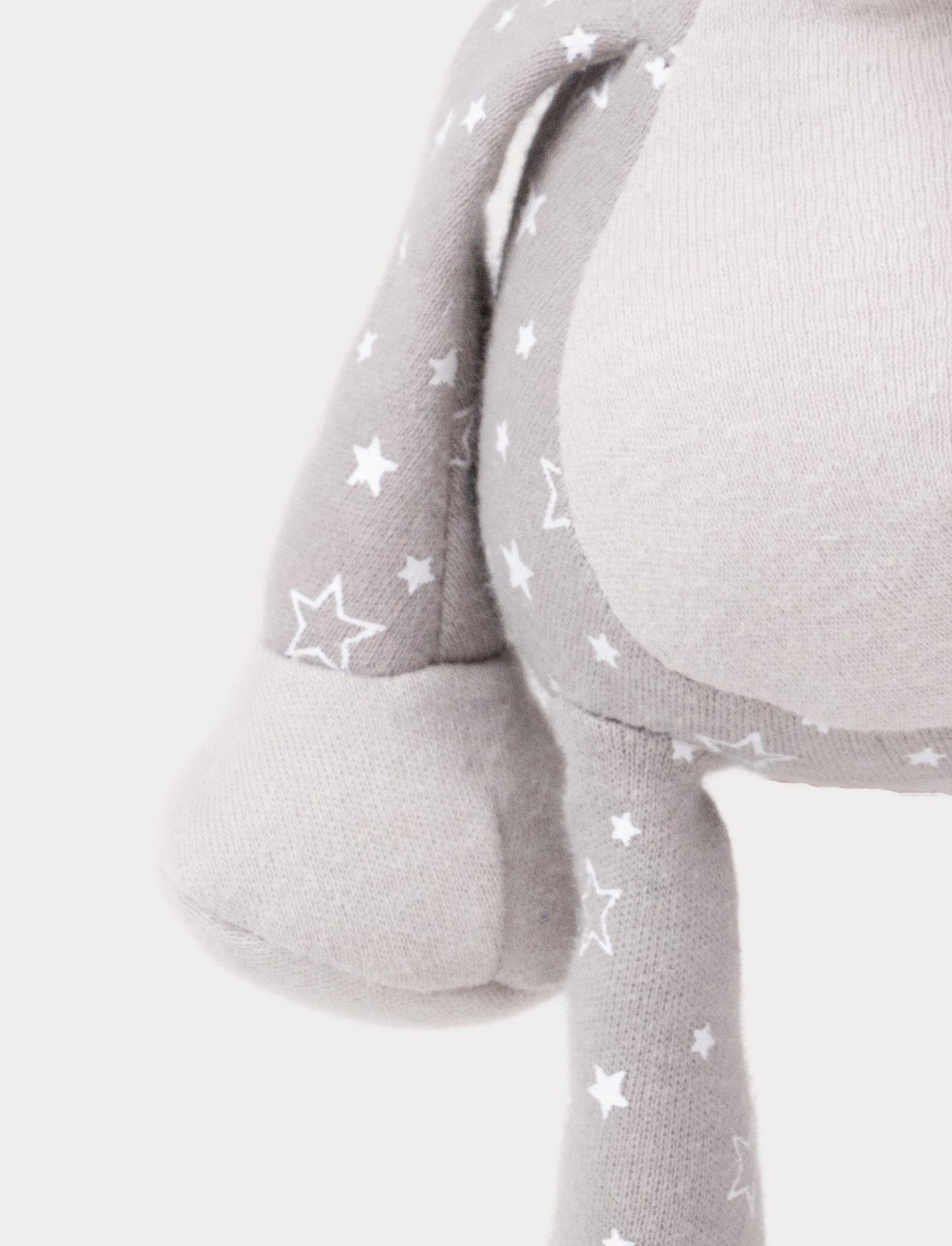 A grey plush elephant music box with star-patterned limbs, large ears, and a fabric loop for hanging