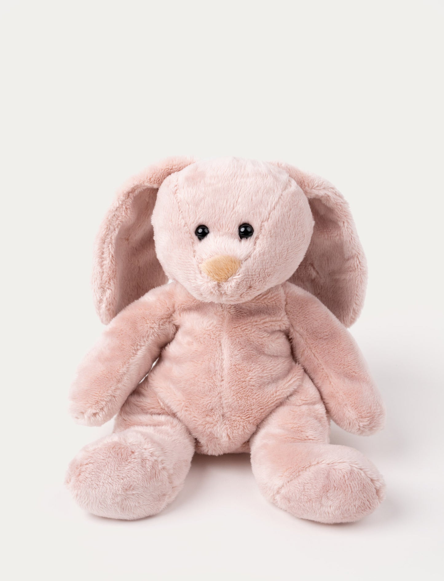 Soft pink bunny plush with long floppy ears, a beige nose, and shiny black eyes.