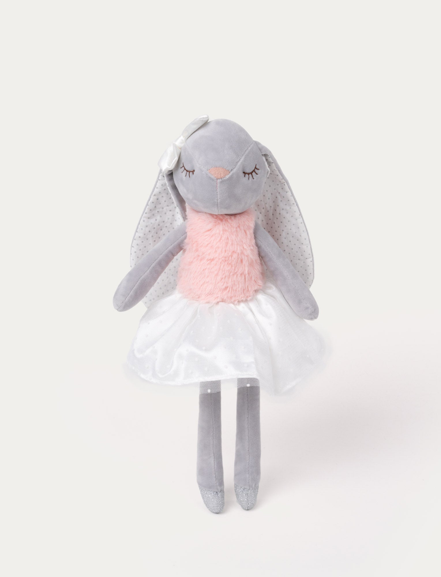 Image of Soft, plush bunny doll with grey fur, long floppy ears, a pink furry chest, a white skirt, and a satin bow on one ear.