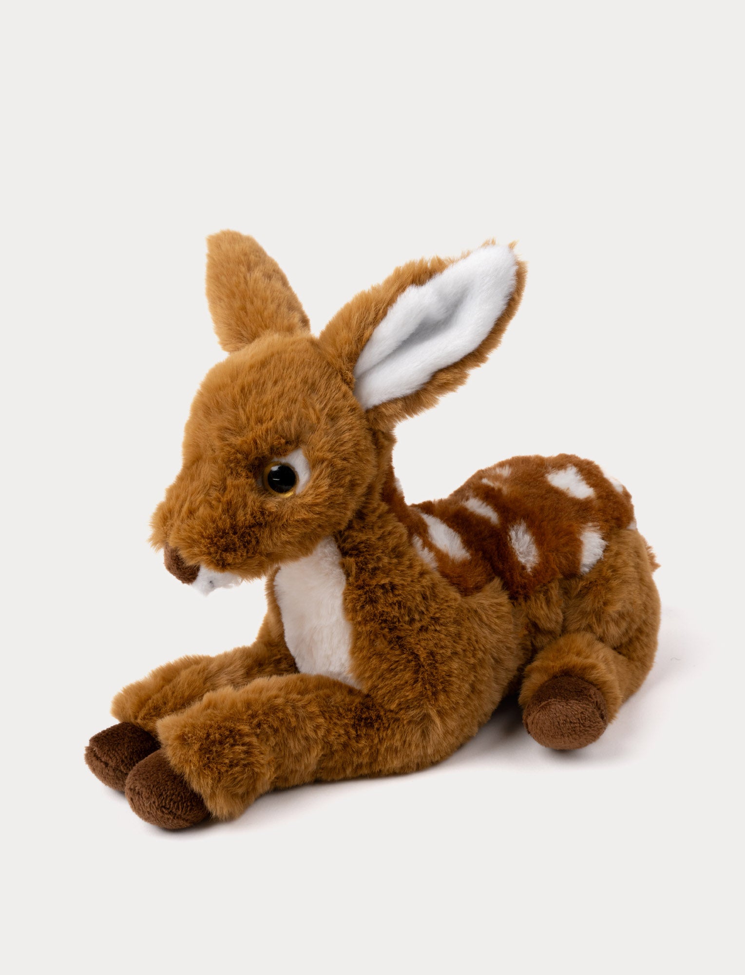 Image of Soft brown deer plush with white spots, large ears, and shiny black eyes, lying down.