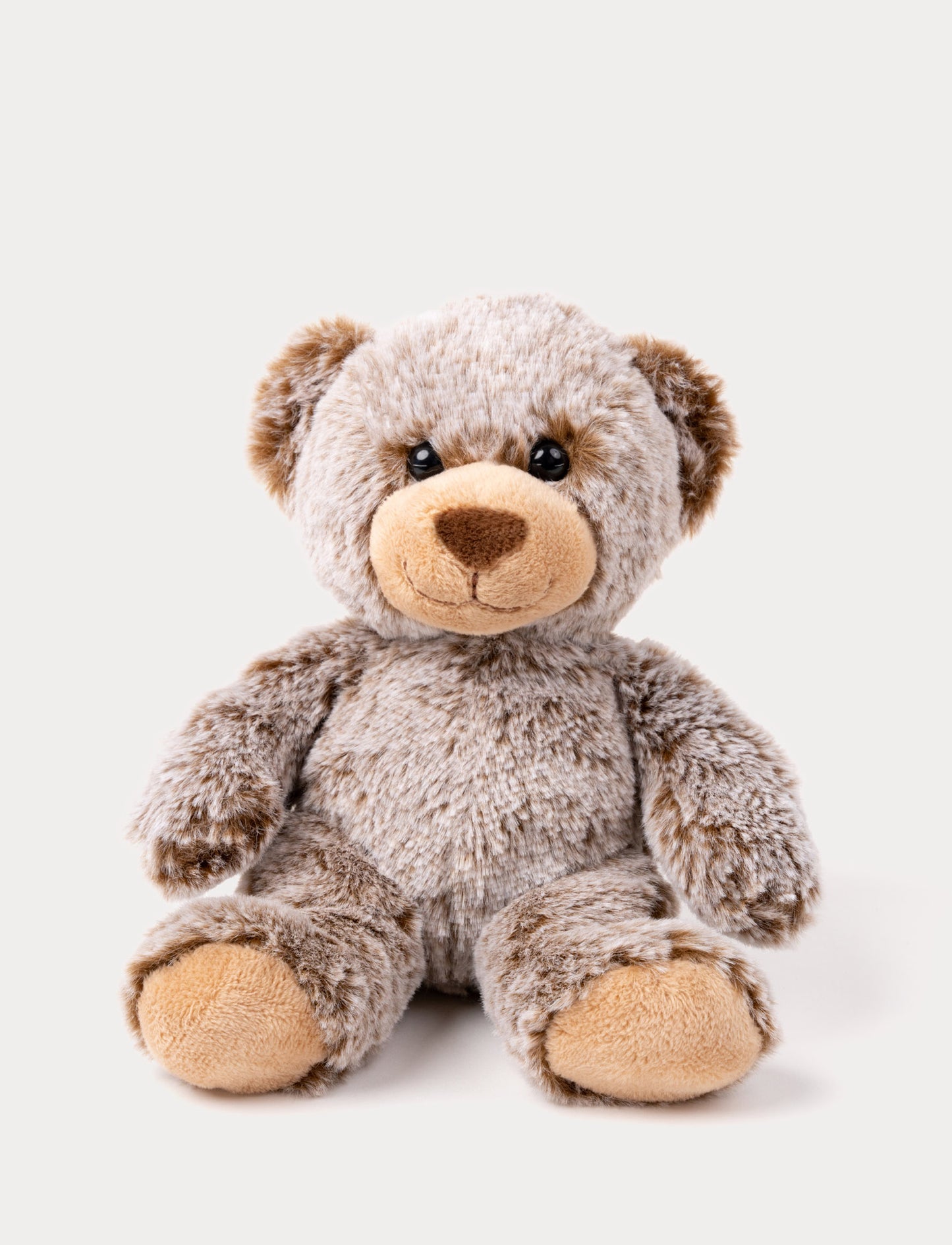 A teddy bear with mottled brown fur, velvety paws, bright eyes, and a cheerful expression.