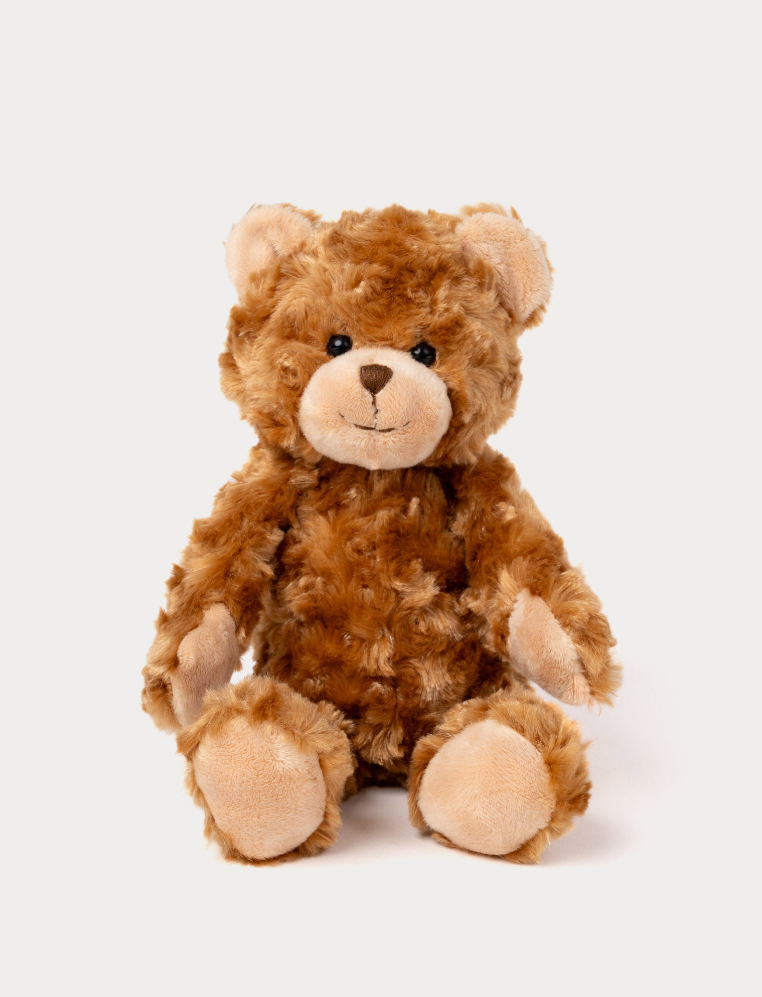 Image of Soft, plush teddy bear with curly golden-brown fur, black button eyes, a stitched nose, and beige paw pads.