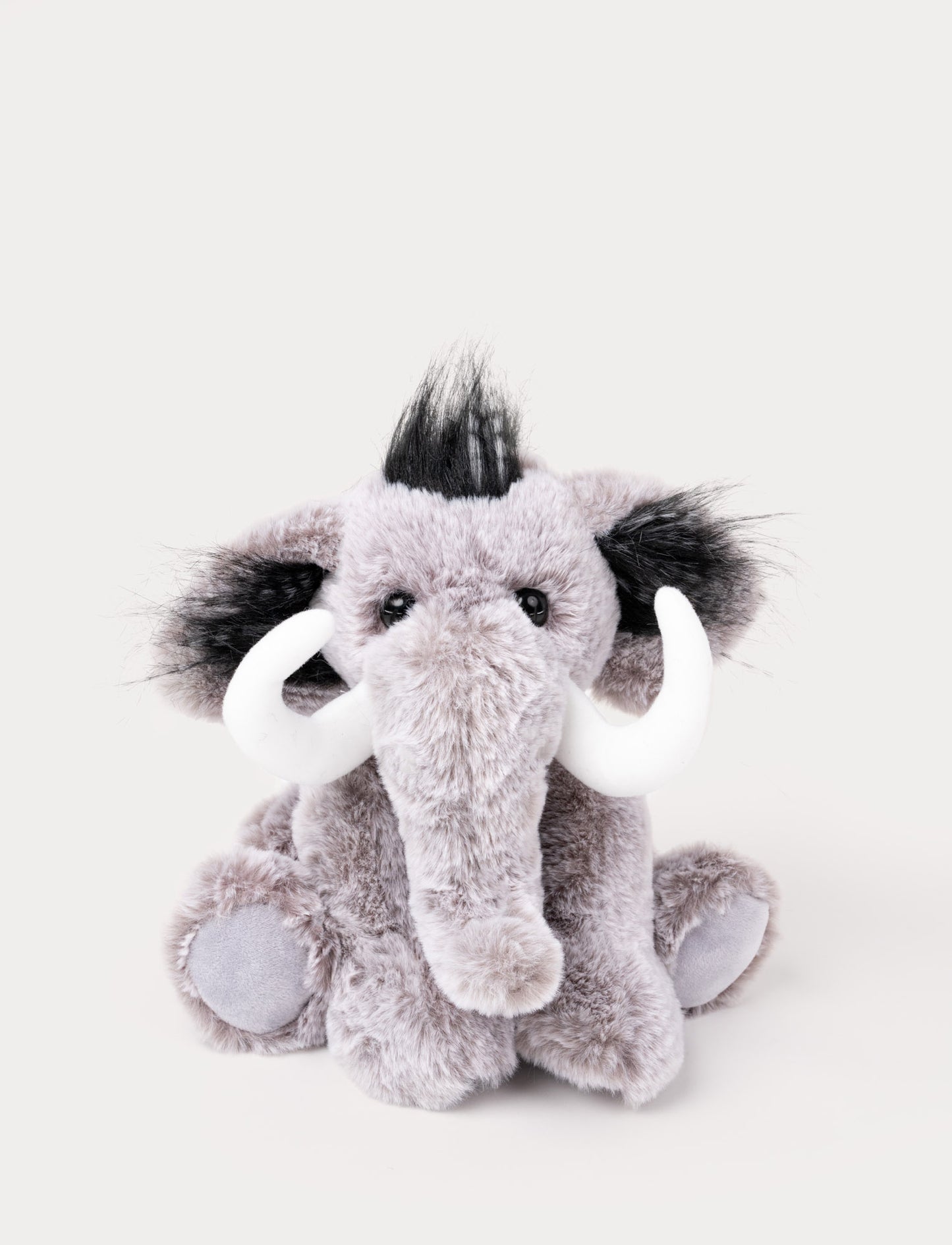 A mammoth with soft gray-mottled fur, long tusks, and a playful hairstyle.
