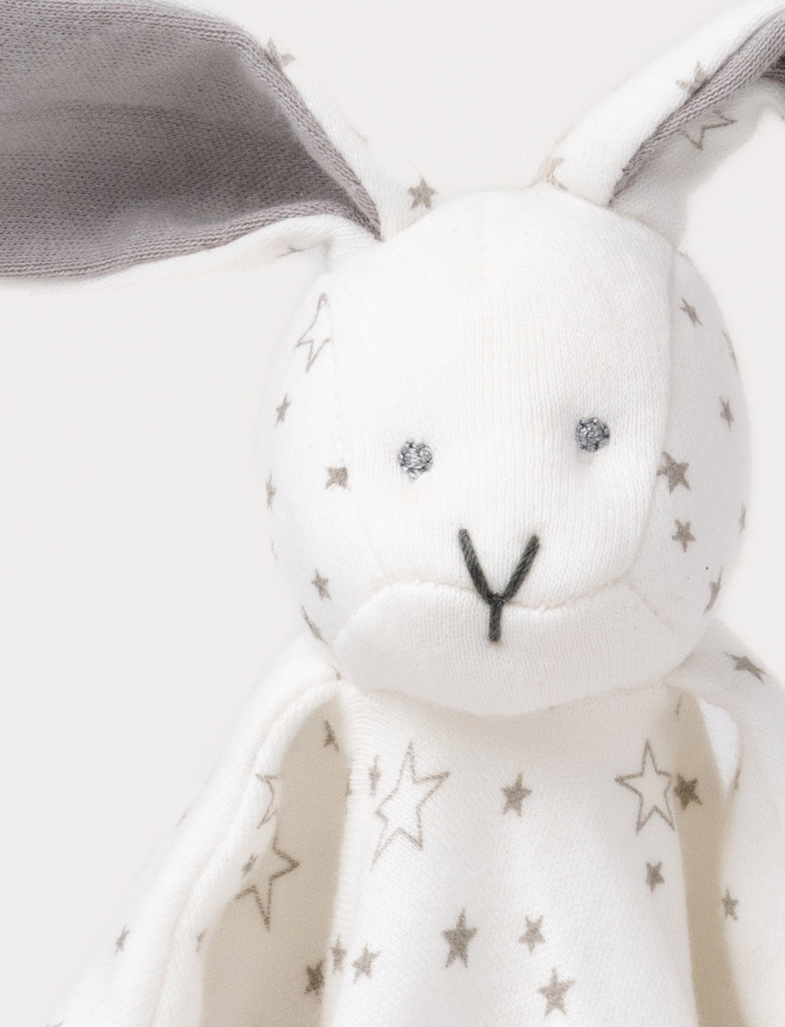 Image of Soft baby blanket with a plush bunny head, long gray ears, and a white star-patterned fabric.