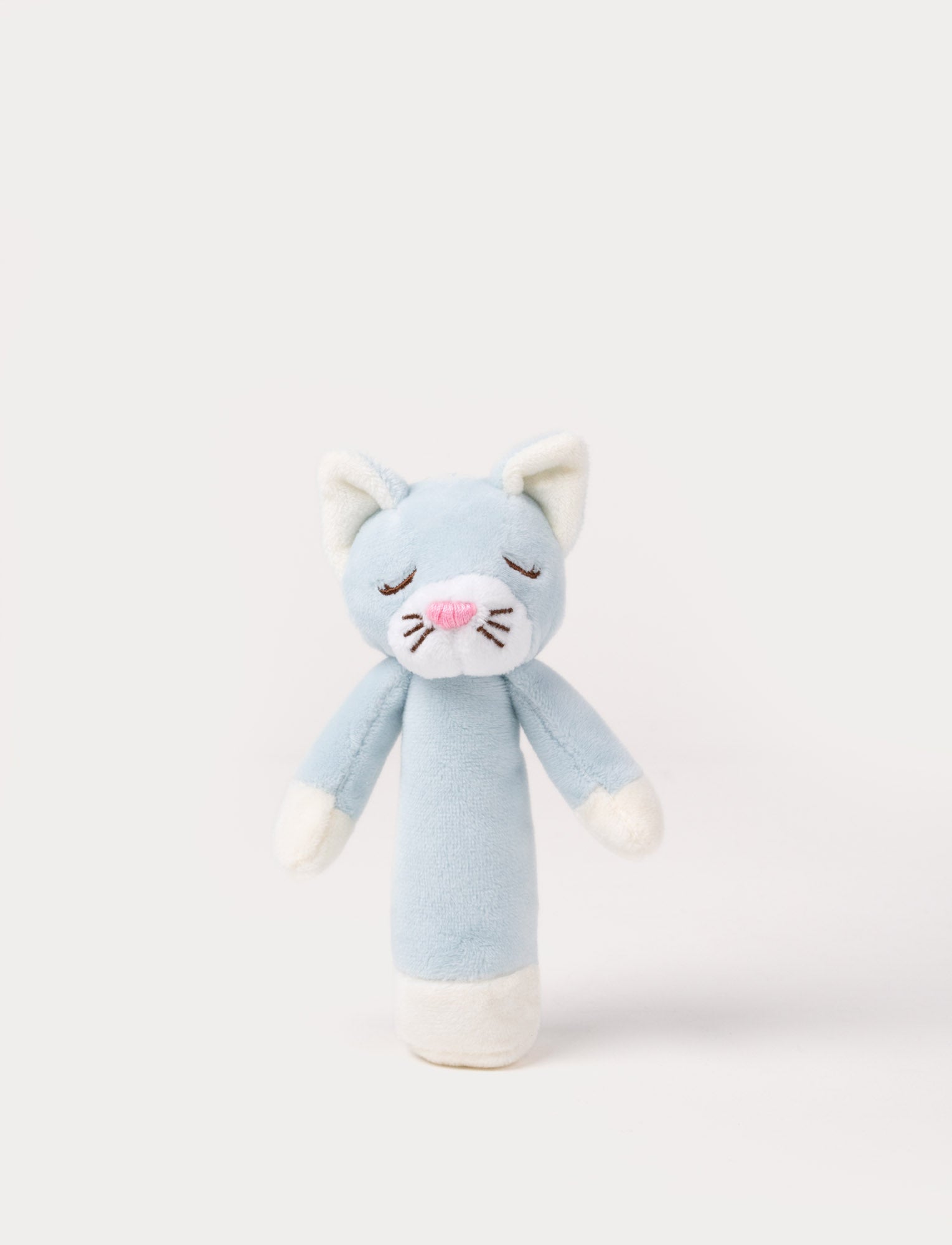 Image of Soft plush cat rattle with a light blue body, embroidered sleeping eyes, a white muzzle, and white accents on the hands and base.