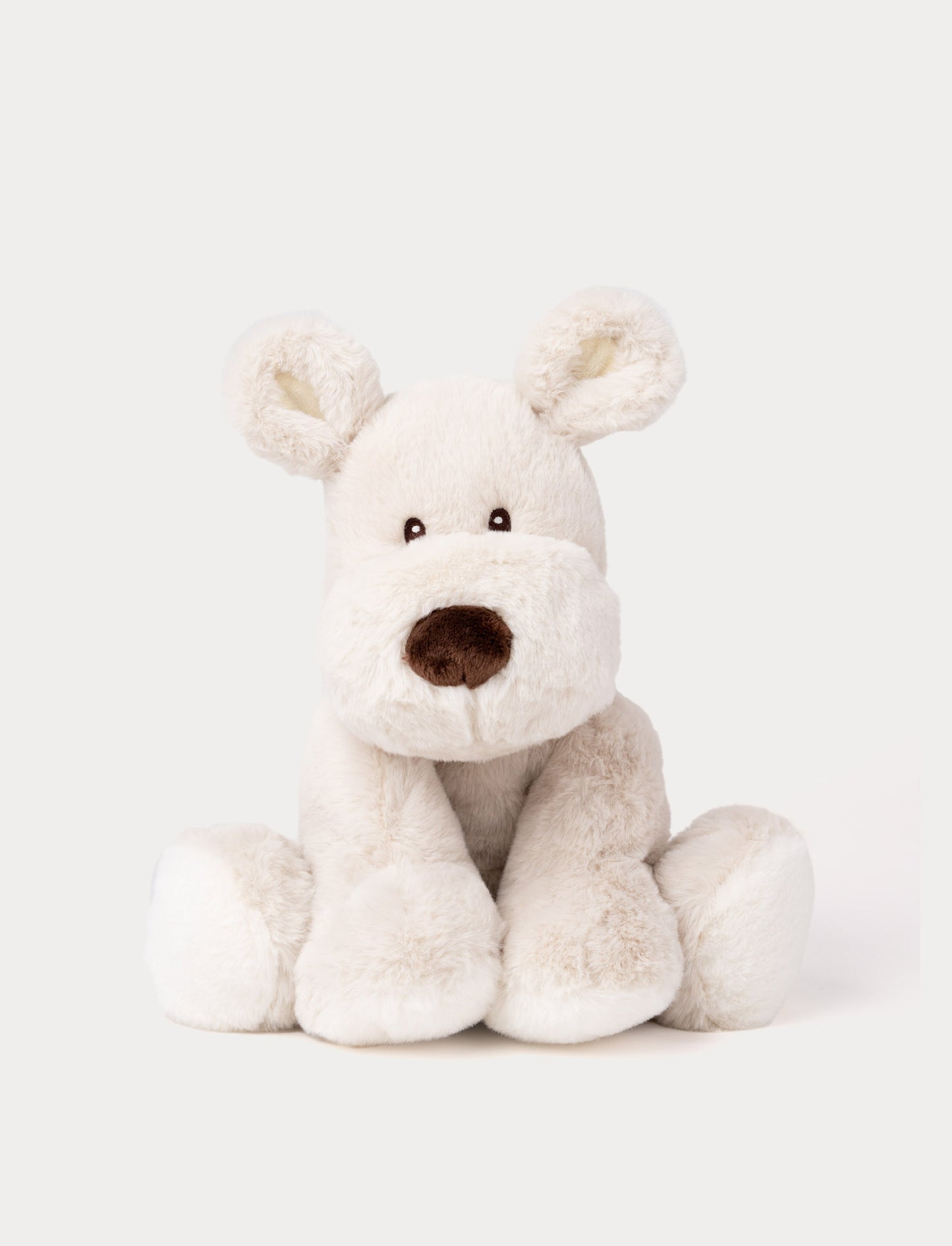 A beige plush dog with soft fur, faux suede detail on its back, and embroidered eyes.