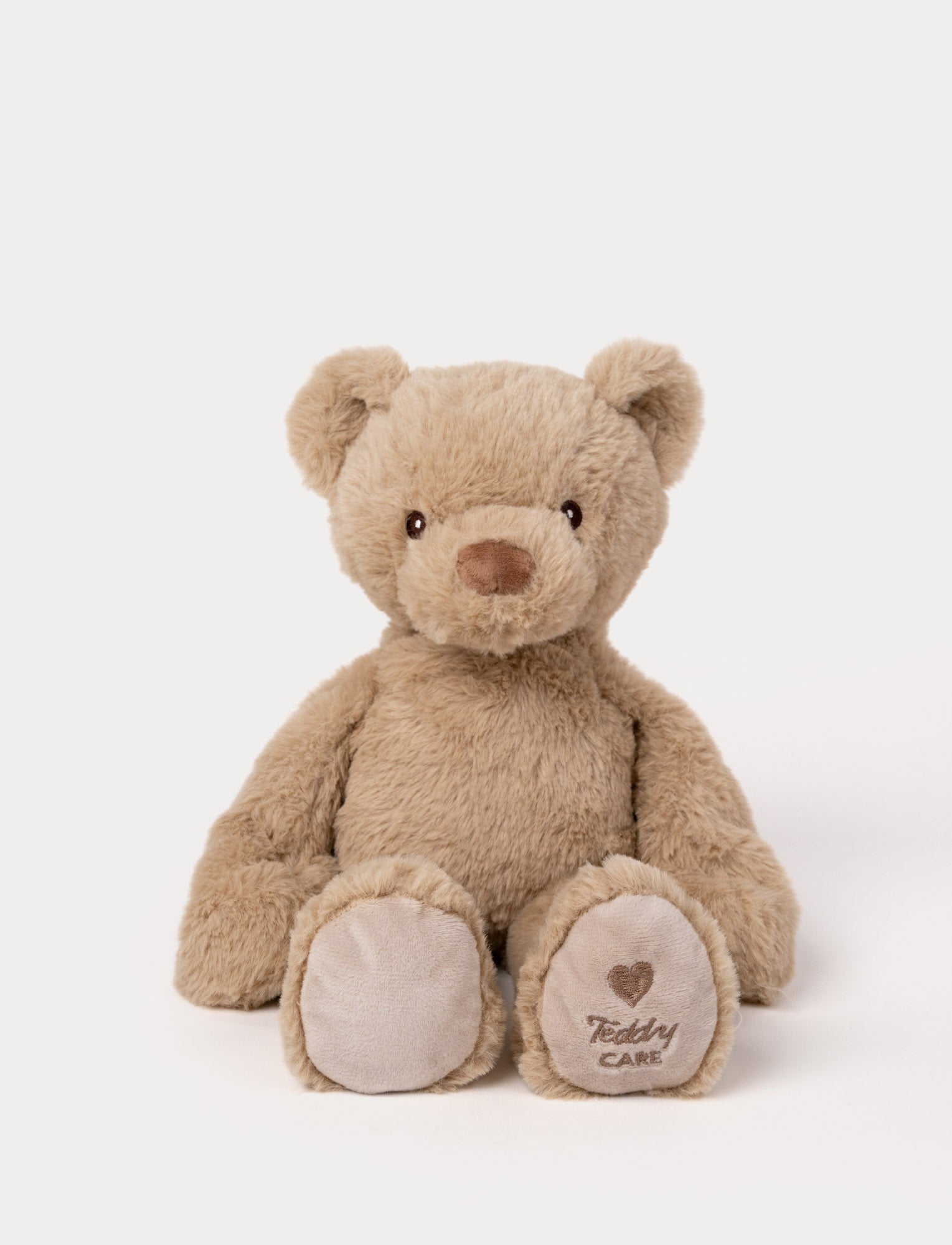 Image of Soft beige teddy bear plush with embroidered eyes, a stitched nose, and "Teddy CARE" embroidered on one paw.