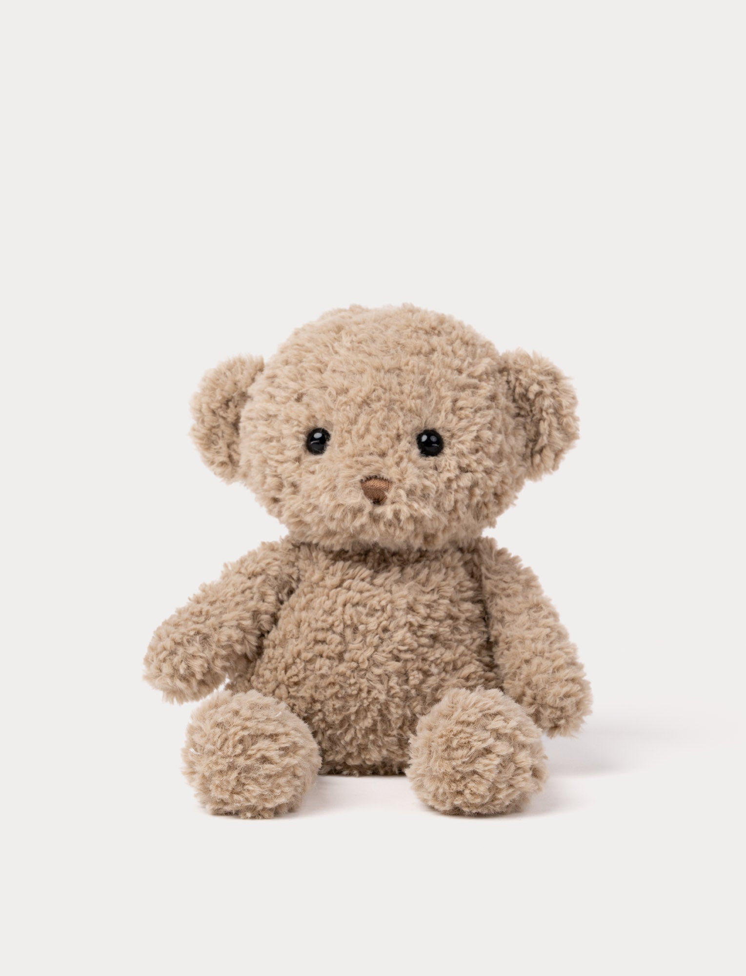 Image of Soft greige teddy bear plush toy with curly fur and cute round ears.