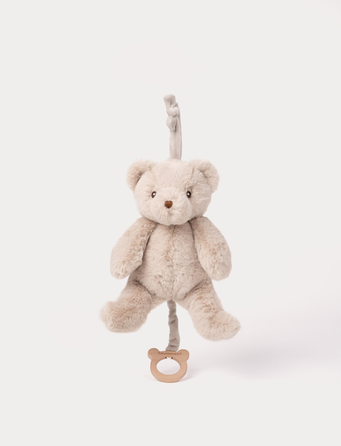 Beige plush teddy bear musical toy with pull string and wooden ring.