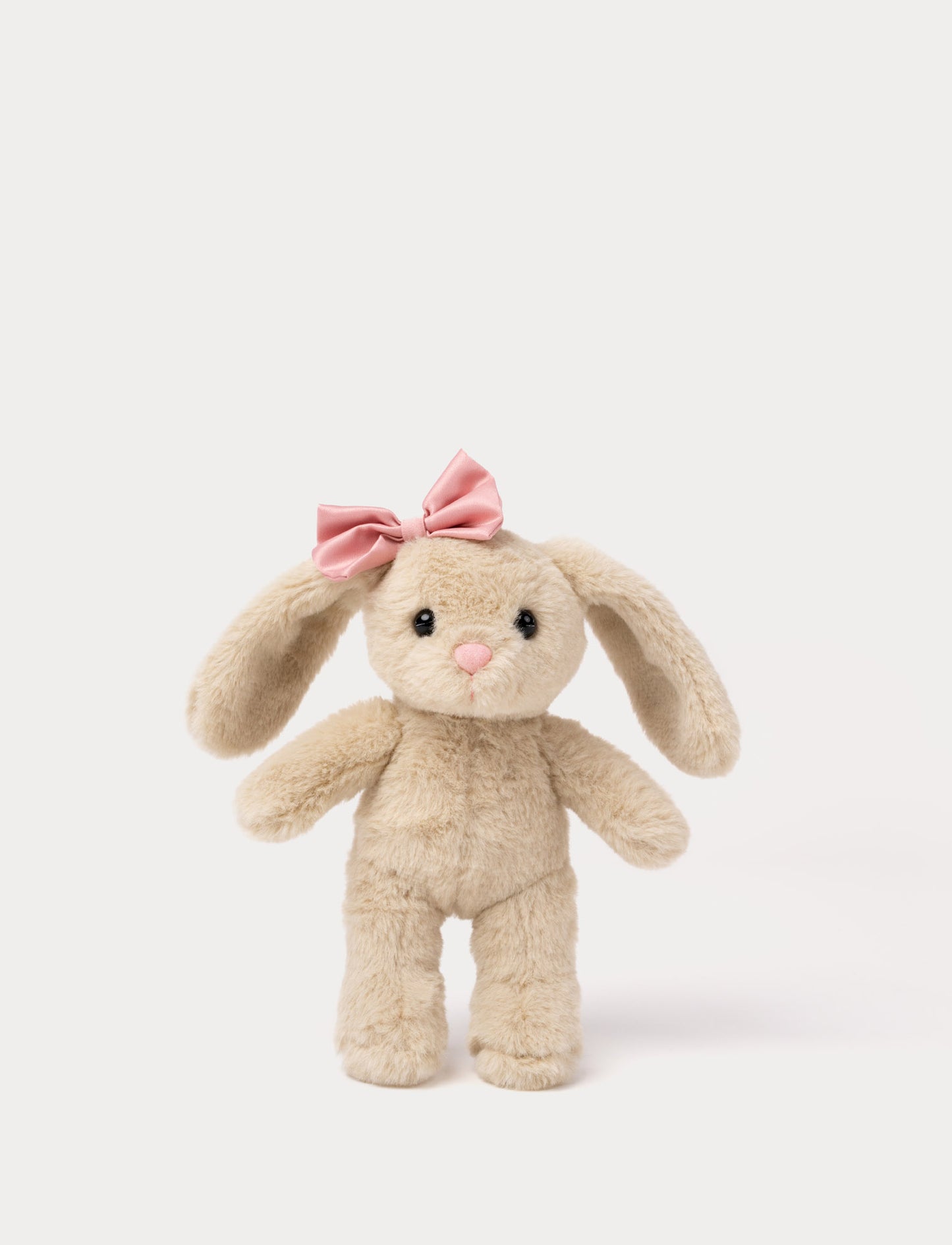 Soft beige bunny plush toy with long ears and pink bow on its head.”