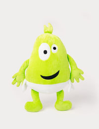 Green plush toy with a tuft on top, large uneven eyes, a playful smile, and a white waistband.