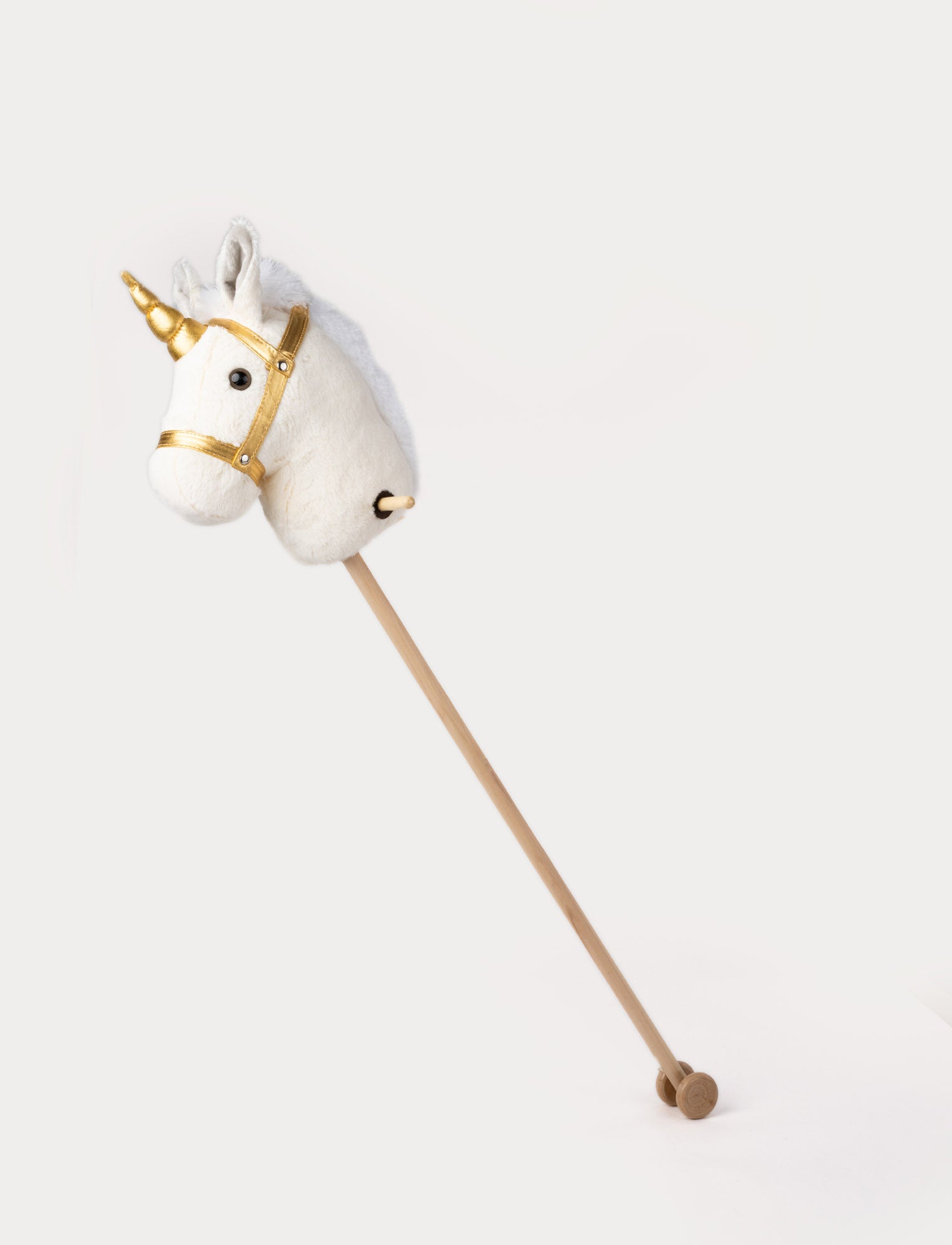  Image of Plush hobby unicorn with a white head, golden horn, matching bridle, and a wooden stick with wheels.