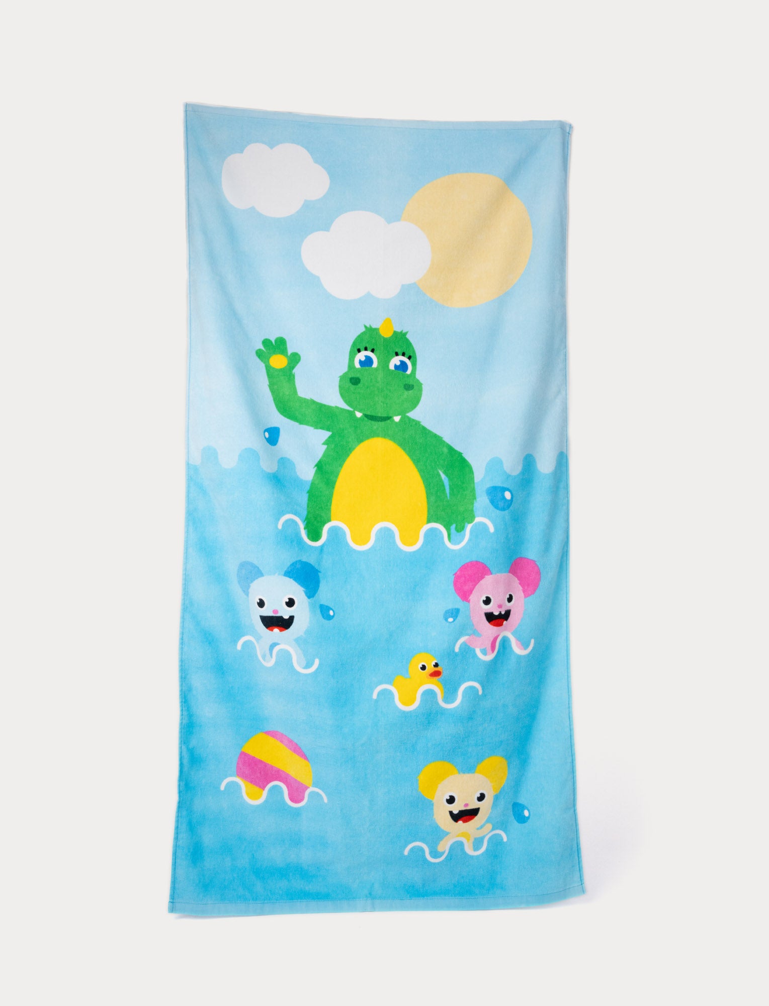  Image of Bolibompa beach towel with a green dragon and colorful characters in the water.