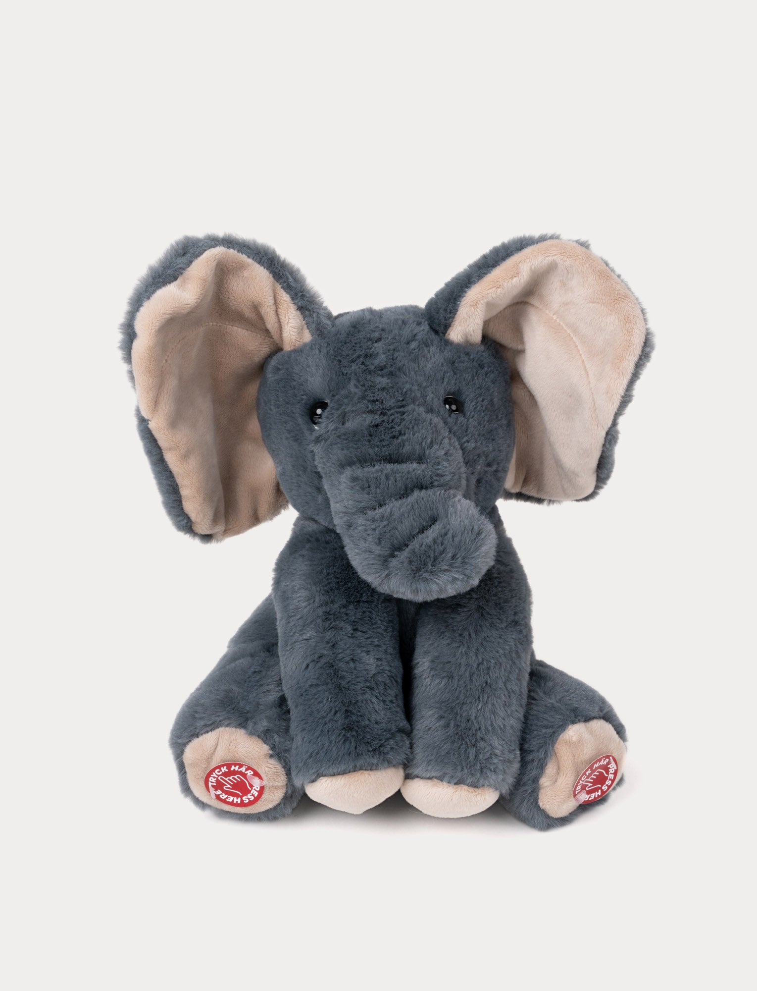  Image of Soft, dark gray plush elephant with large beige ears, black eyes, and interactive buttons on its feet.