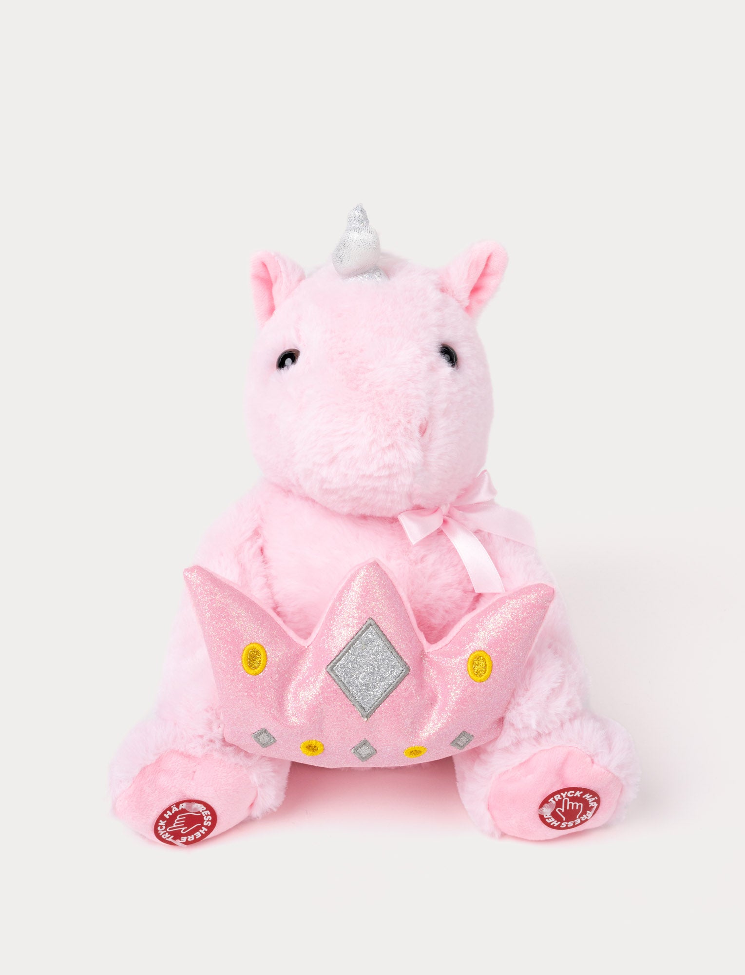  Image of Soft pink plush unicorn with a silver horn, a pink ribbon, and a glittery pink crown, featuring interactive buttons on its feet.