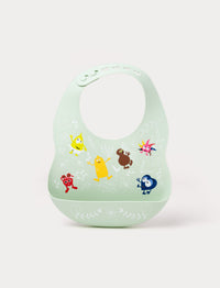 A soft green silicone baby bib with Babblarna characters and a leaf pattern, featuring a built-in food catcher.