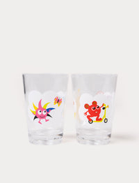 Two clear drinking glasses featuring Babblarna characters, one with a pink creature and a butterfly, the other with a red creature on a scooter.