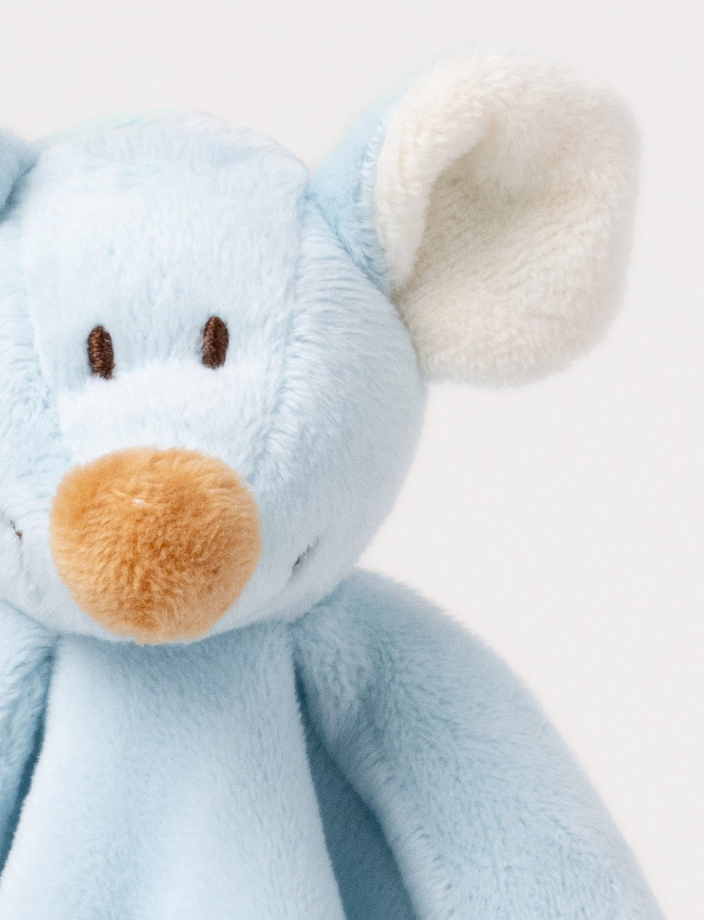 A soft blue baby blanket with a plush mouse, beige contrast details