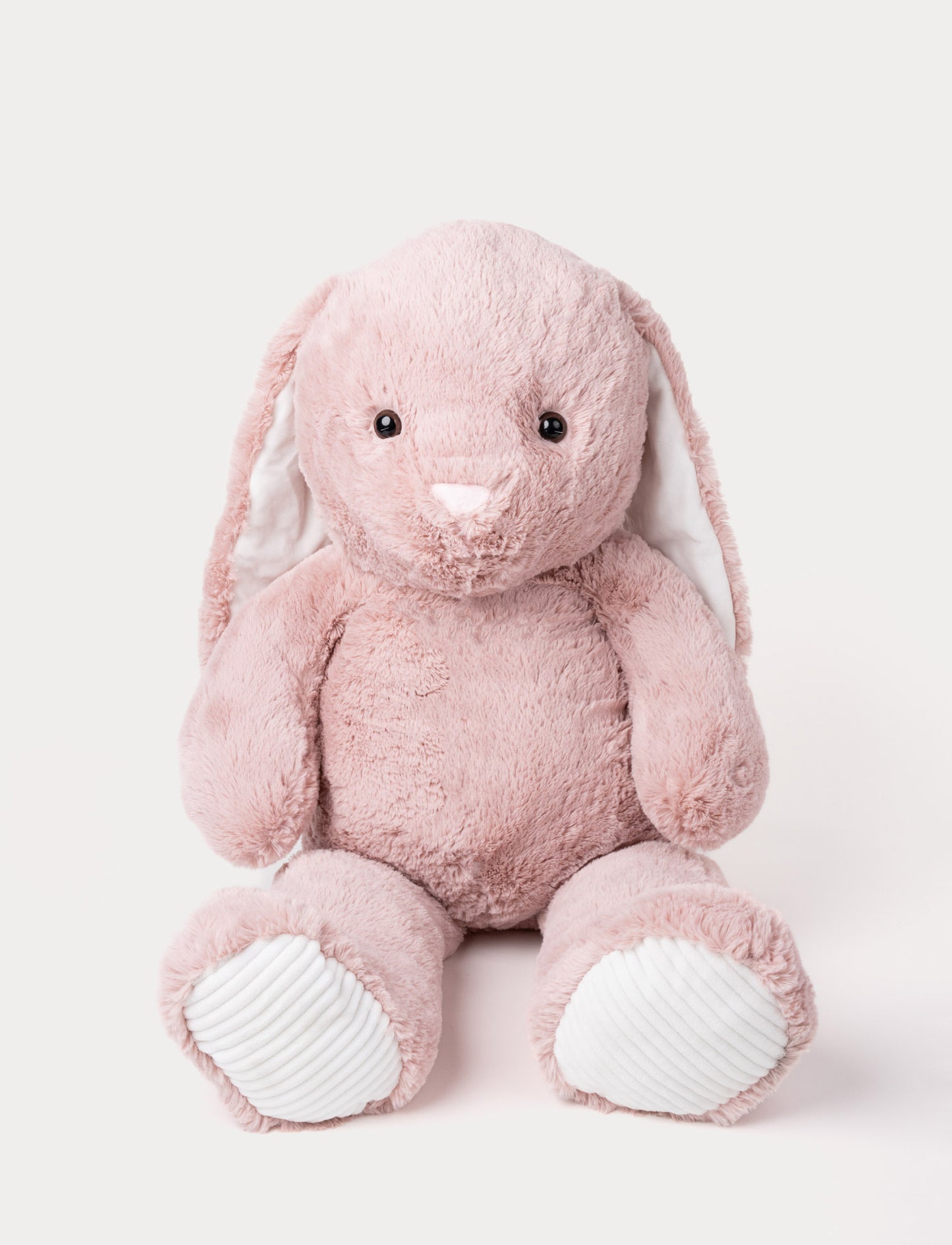 Soft pink plush bunny with long floppy ears, a pink nose, and ribbed white fabric on its paws.